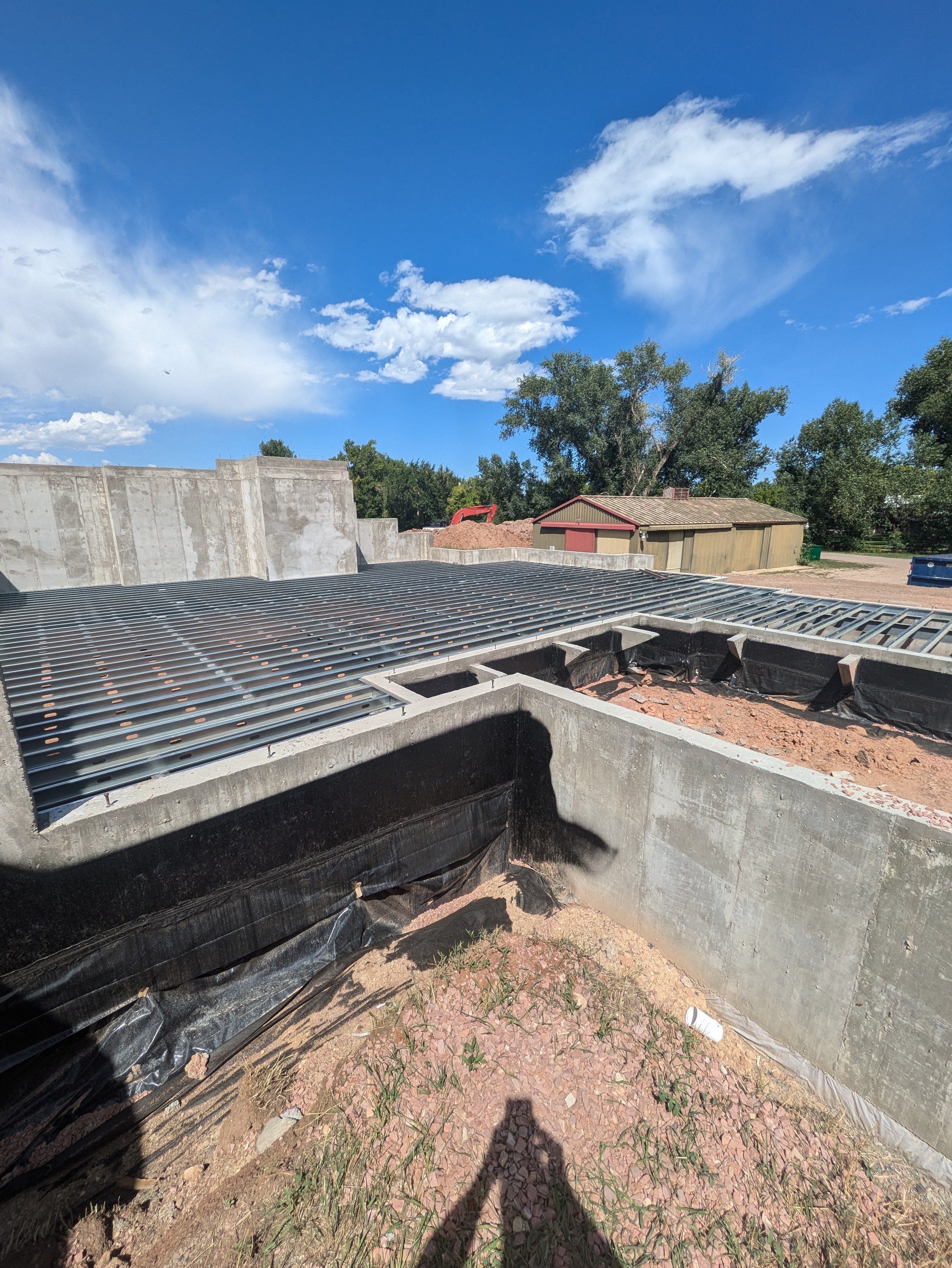 Steel joists being installed for a structural floor in Colorado with a blue sky in the background