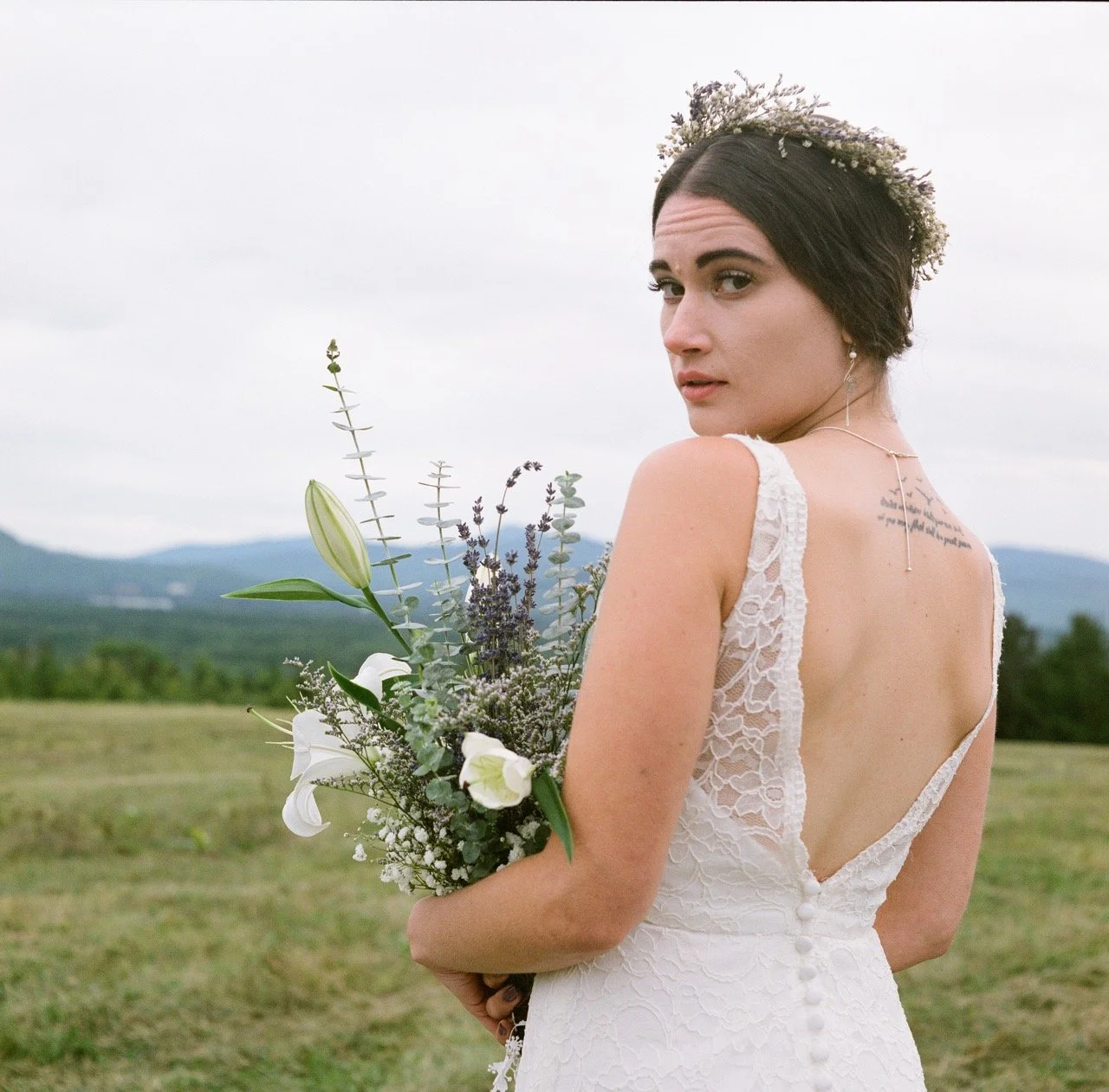 Bride looking over her shoulder while holding bouquet