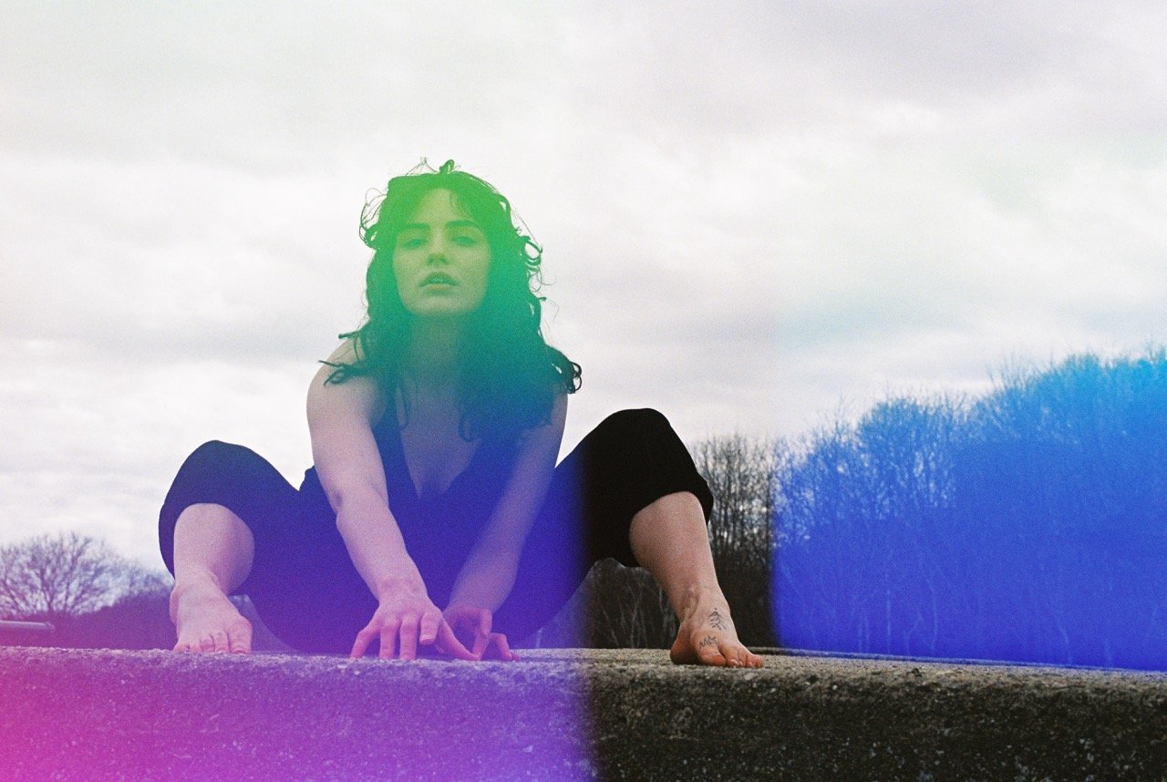 Woman sitting and leaning forward surrounded by nature