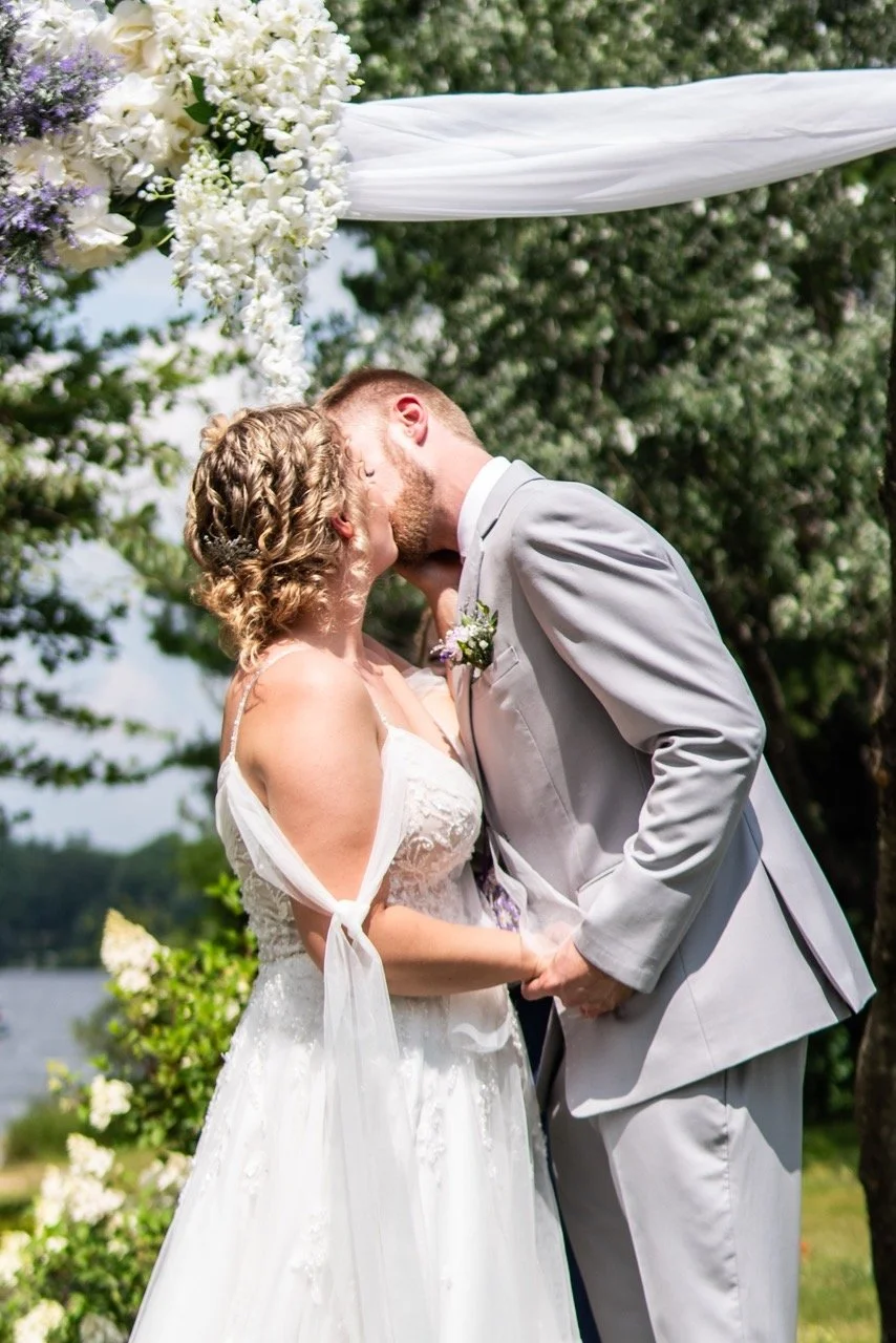 Bride and groom kissing during their outdoor ceremony