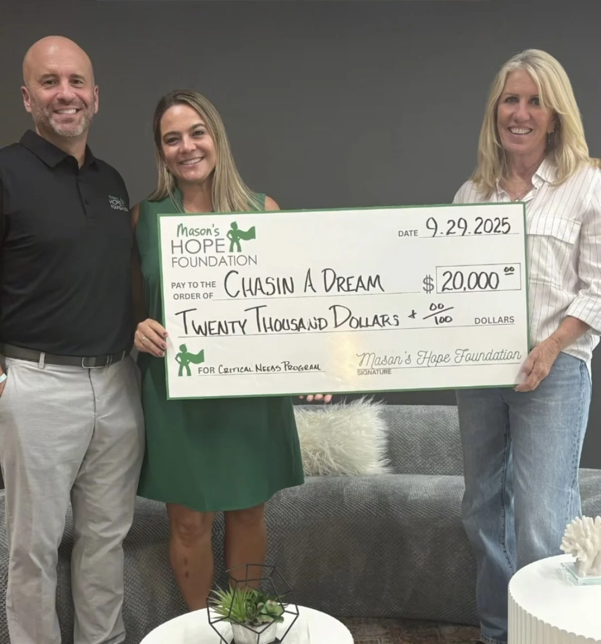 Three people standing indoors holding a large check made out to Chasin A Dream for twenty thousand dollars from Mason's Hope Foundation, dated September 29, 2025.