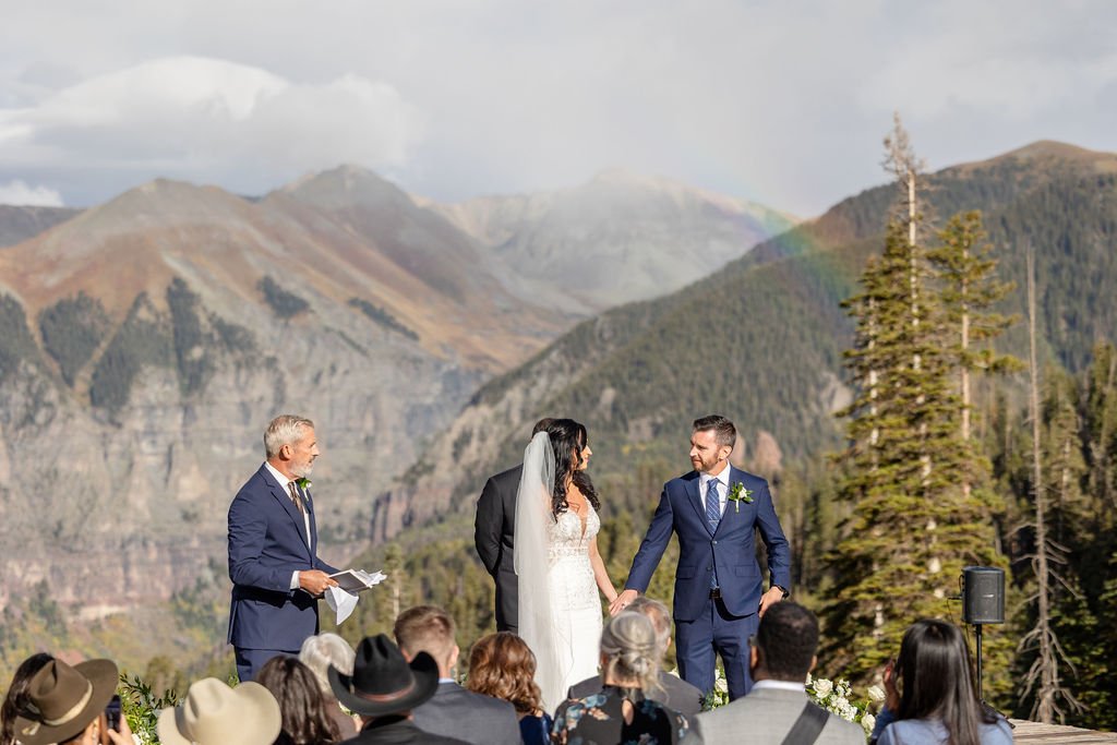 Rainbow behind bride and groom during ceremony at San Sophia