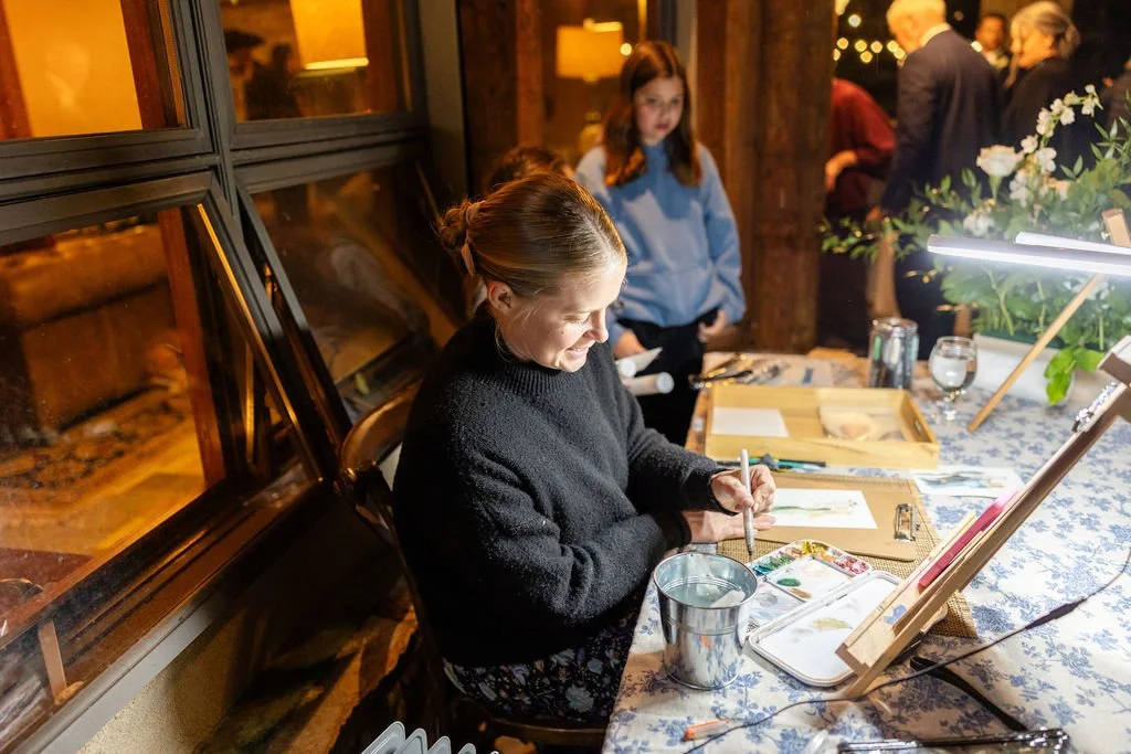 Live painter paints guest portraits during wedding reception