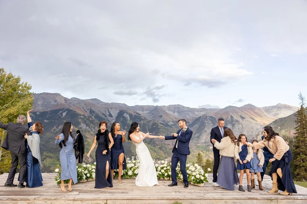 Bride and groom dance with their guests on platform at San Sophia with floral ground arch