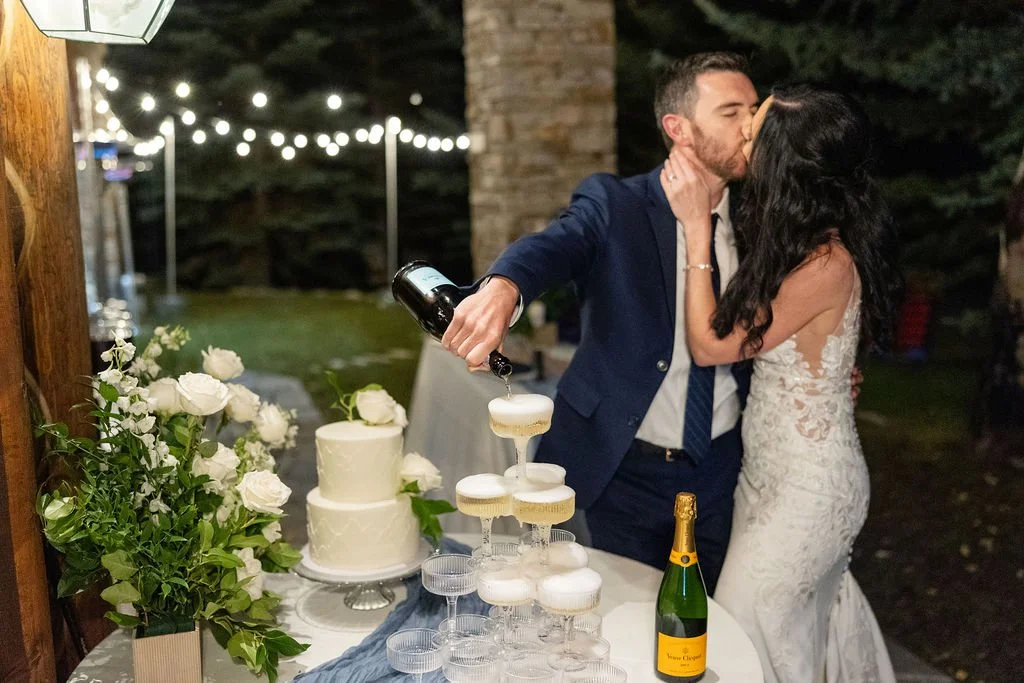 Bride and groom cut wedding cake and pour champagne tower