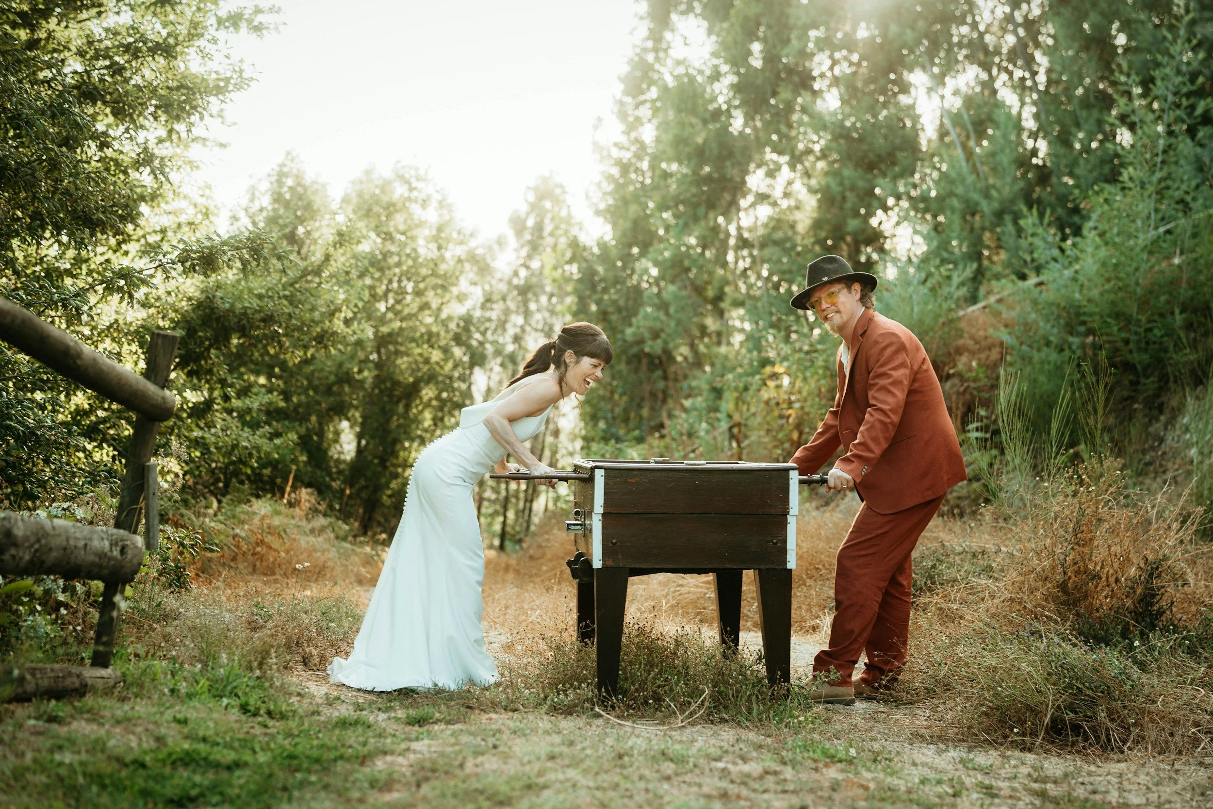 a couple in wedding clothes play foozeball