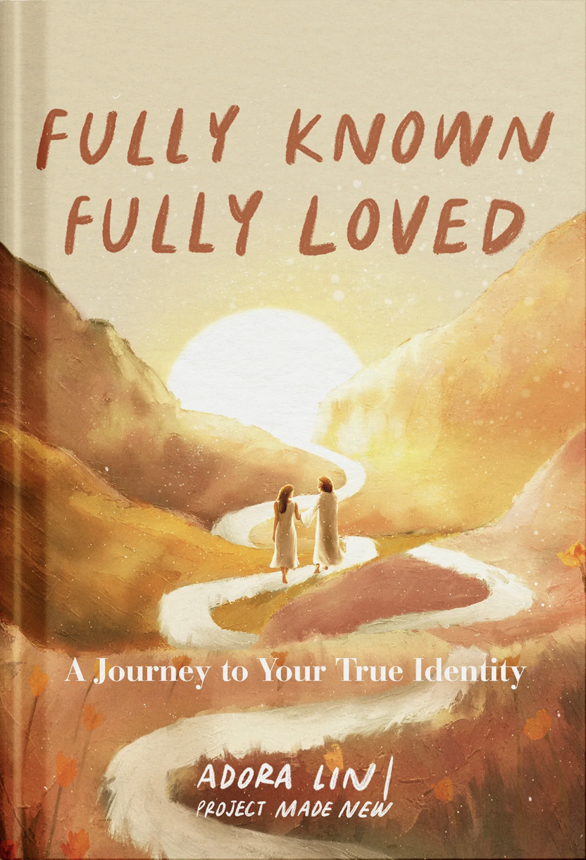 Book cover titled 'Fully Known Fully Loved: A Journey to Your True Identity' by Adora LIN, featuring a painting of two women holding hands, walking along a winding path through a canyon with a bright sun setting behind mountains.