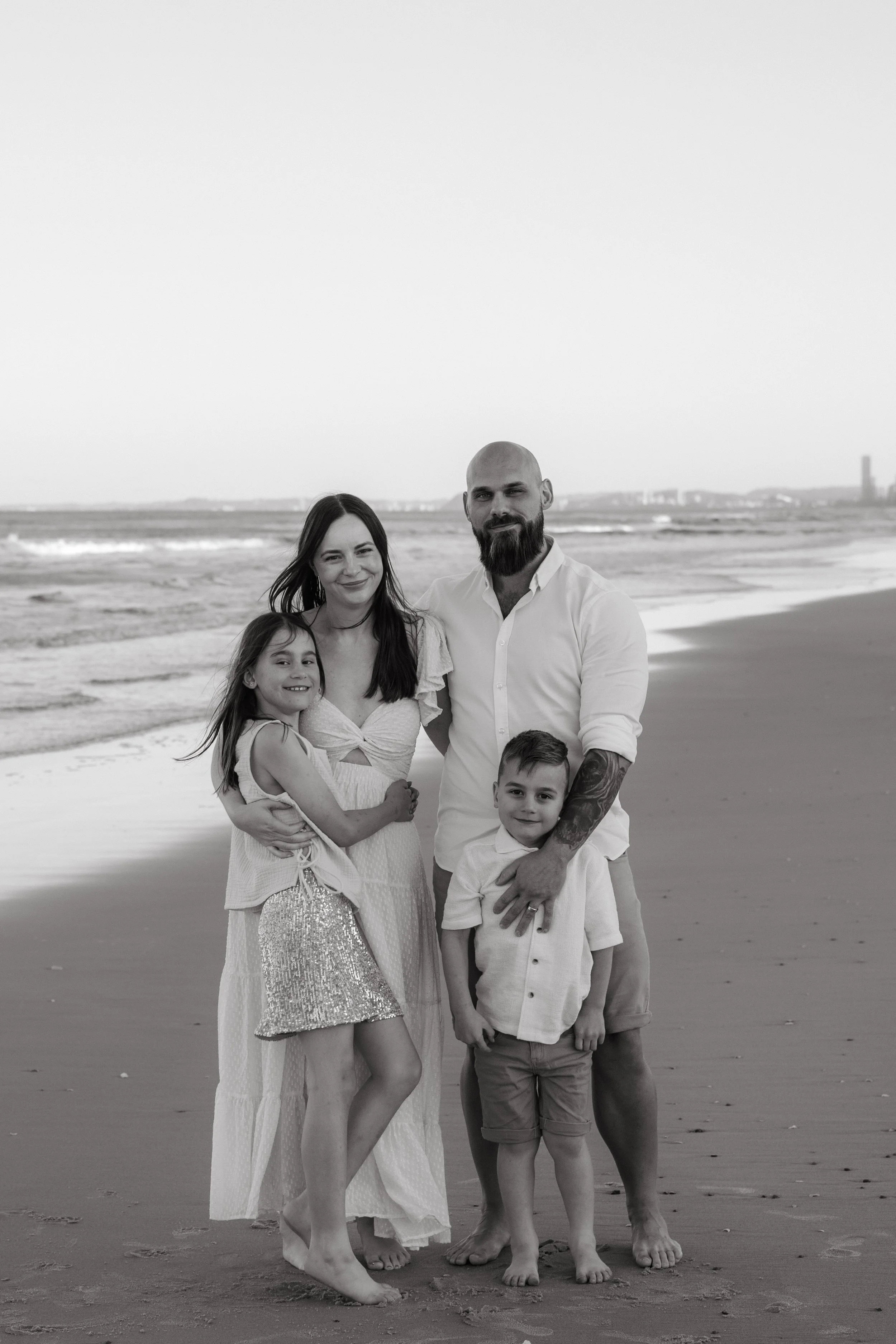 Black and white photo of a family standing together on the beach, used to represent the founder’s family and personal ‘why’ behind the business.