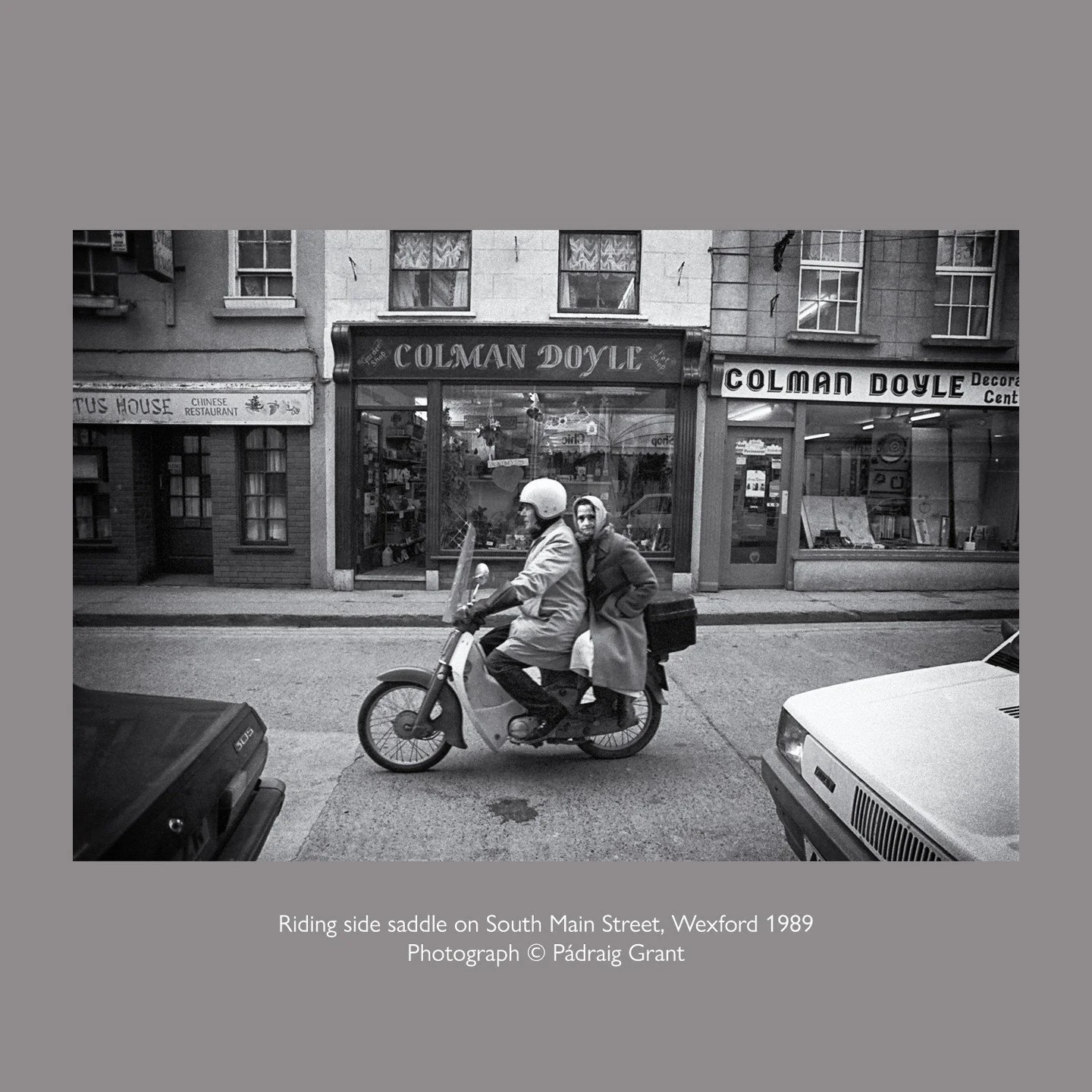 Riding side saddle on South Main Street, Wexford in 1989
Photograph &copy; P&aacute;draig Grant

#padraiggrantswexford #streetphotography #filmphotography #blackandwhitephotography #honda50 #sidesaddle