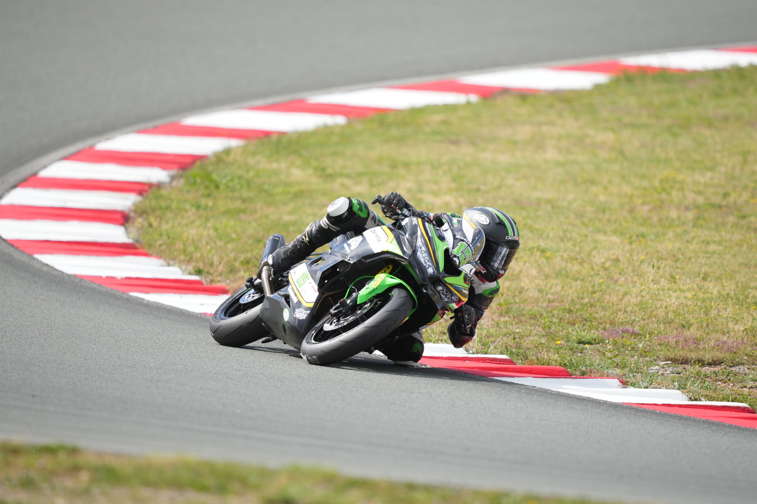 Motorcycle racer leaning into a turn on a racetrack