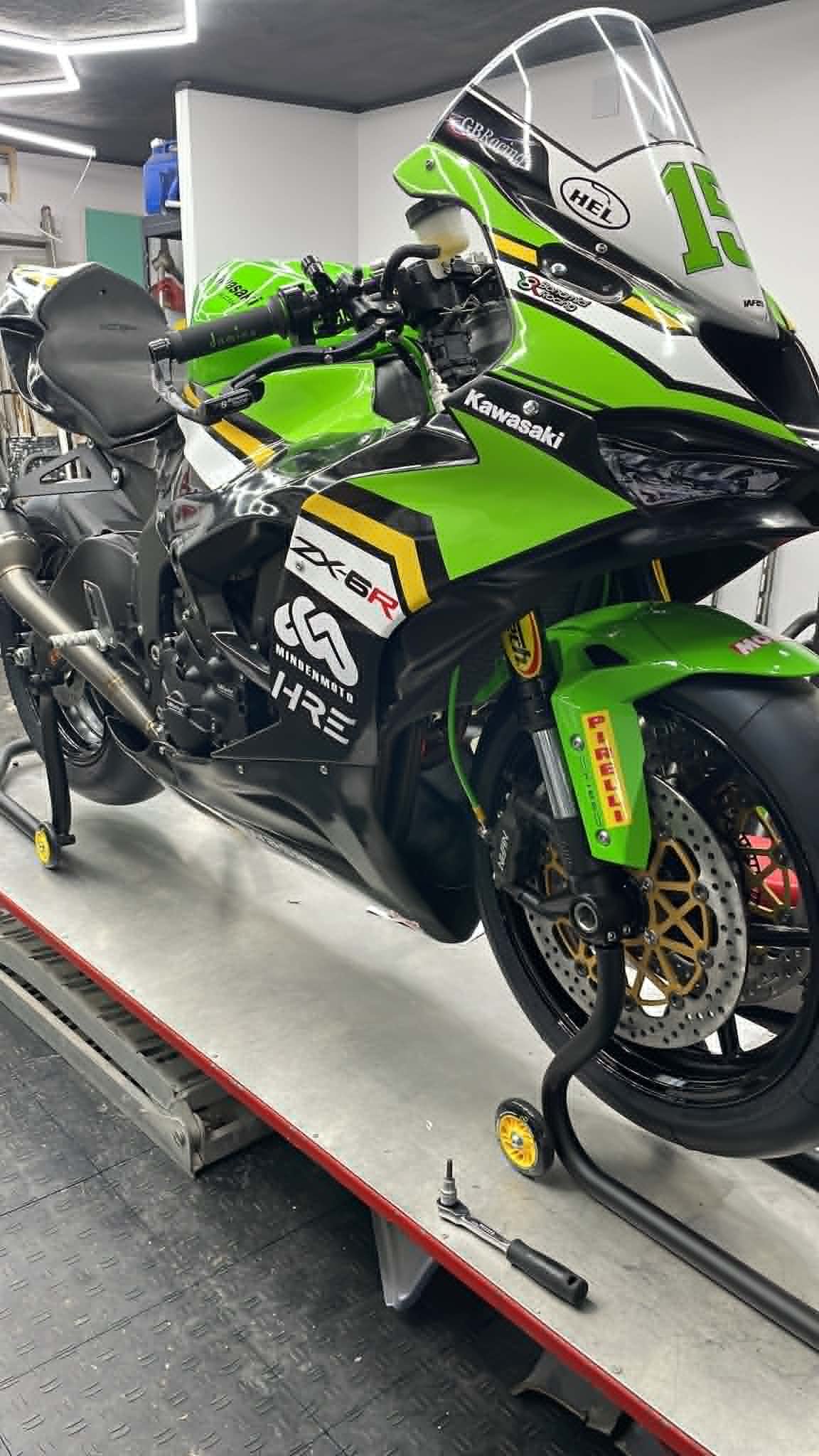 Green Kawasaki race motorcycle on a workbench at Minden Moto