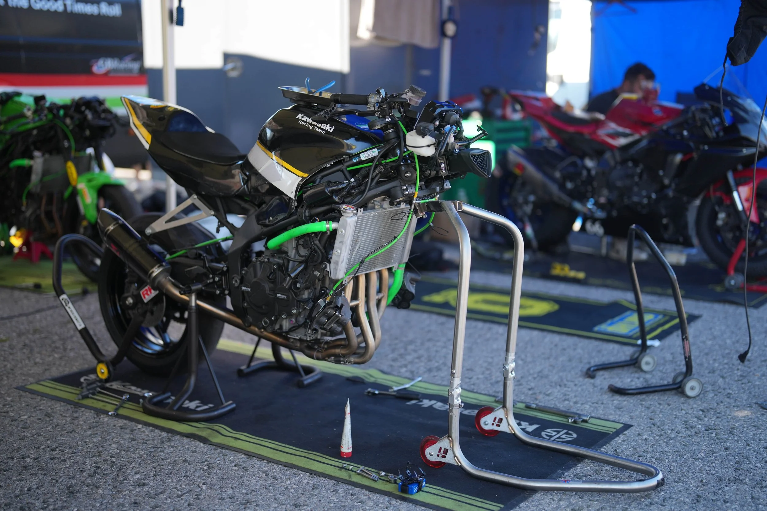 A black Kawasaki race bike without front suspension on stands getting prepeared for the track bike service kawasaki zx4rr for sale 