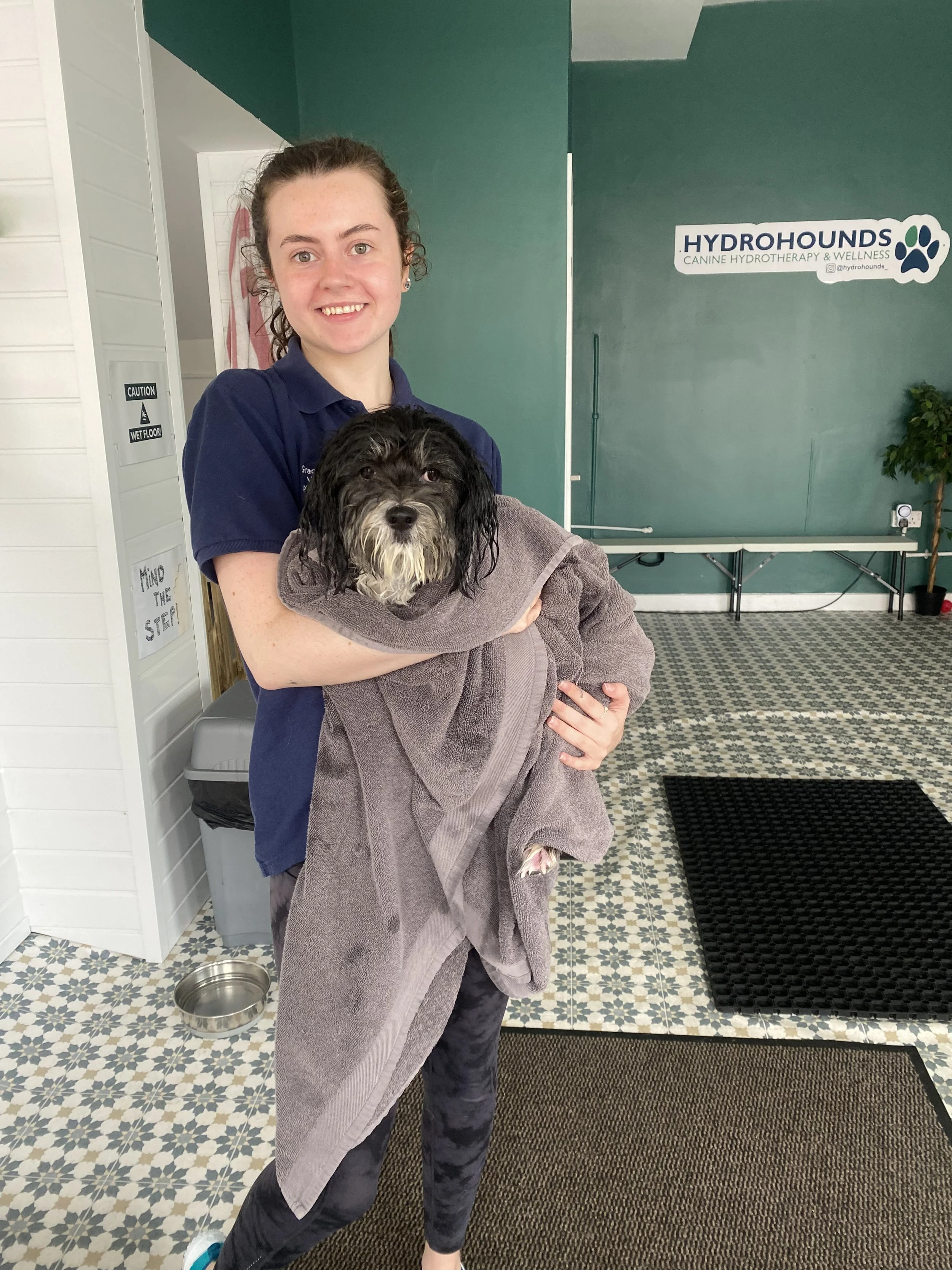 veterinary physiotherapist holding dog after hydrotherapy treatment