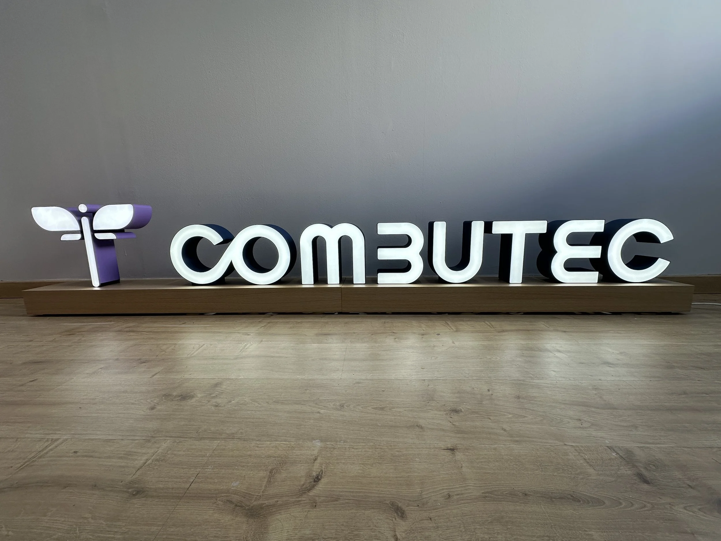 Logo para COMBUTEC iluminado de dos metros y medio de longitud diseñado desde cero, impreso en filamento multicolor, electrificado con LED y montado con un sistema de encaje central.