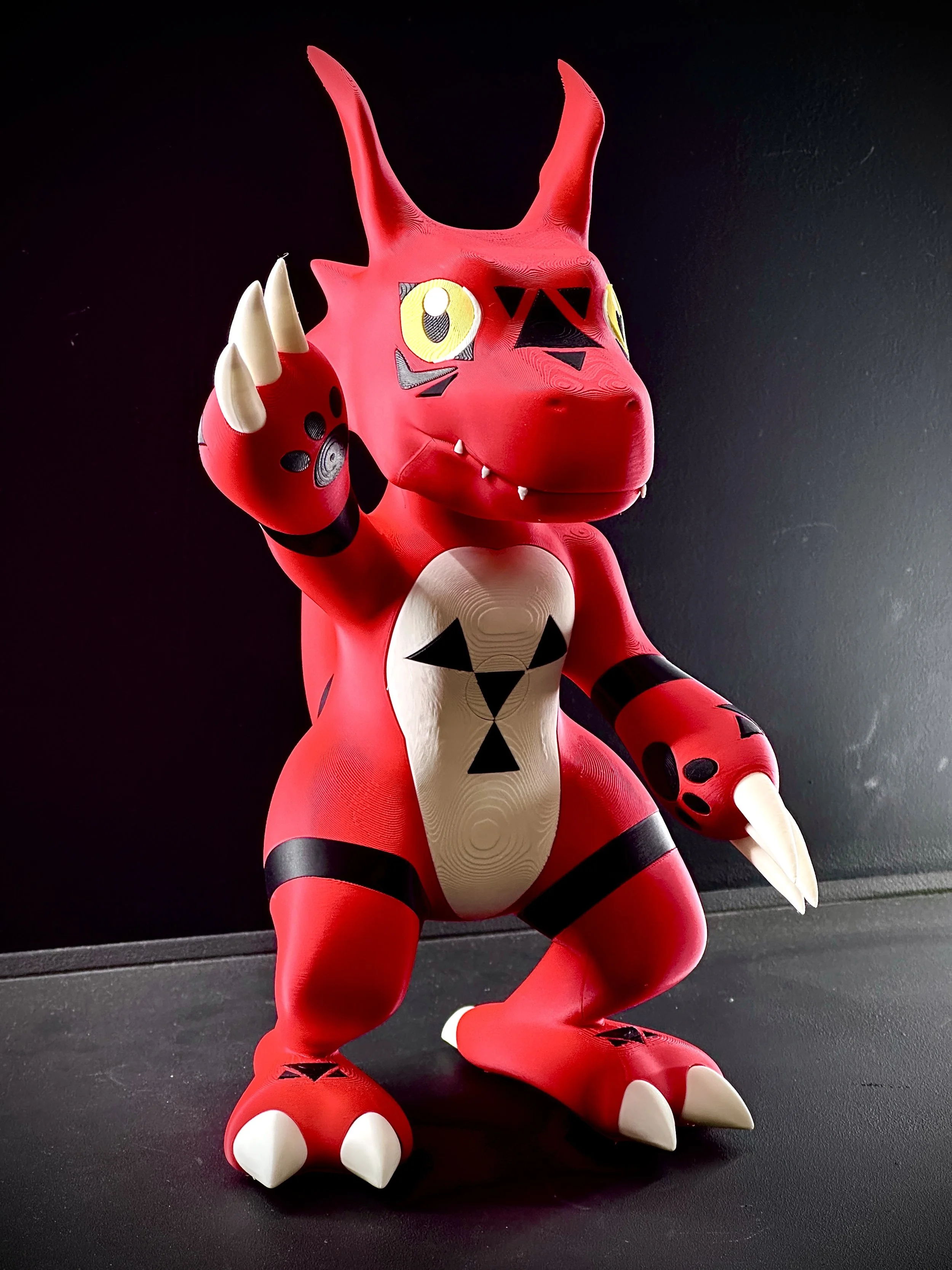 Figura de Guilmon impresa en filamento a color.