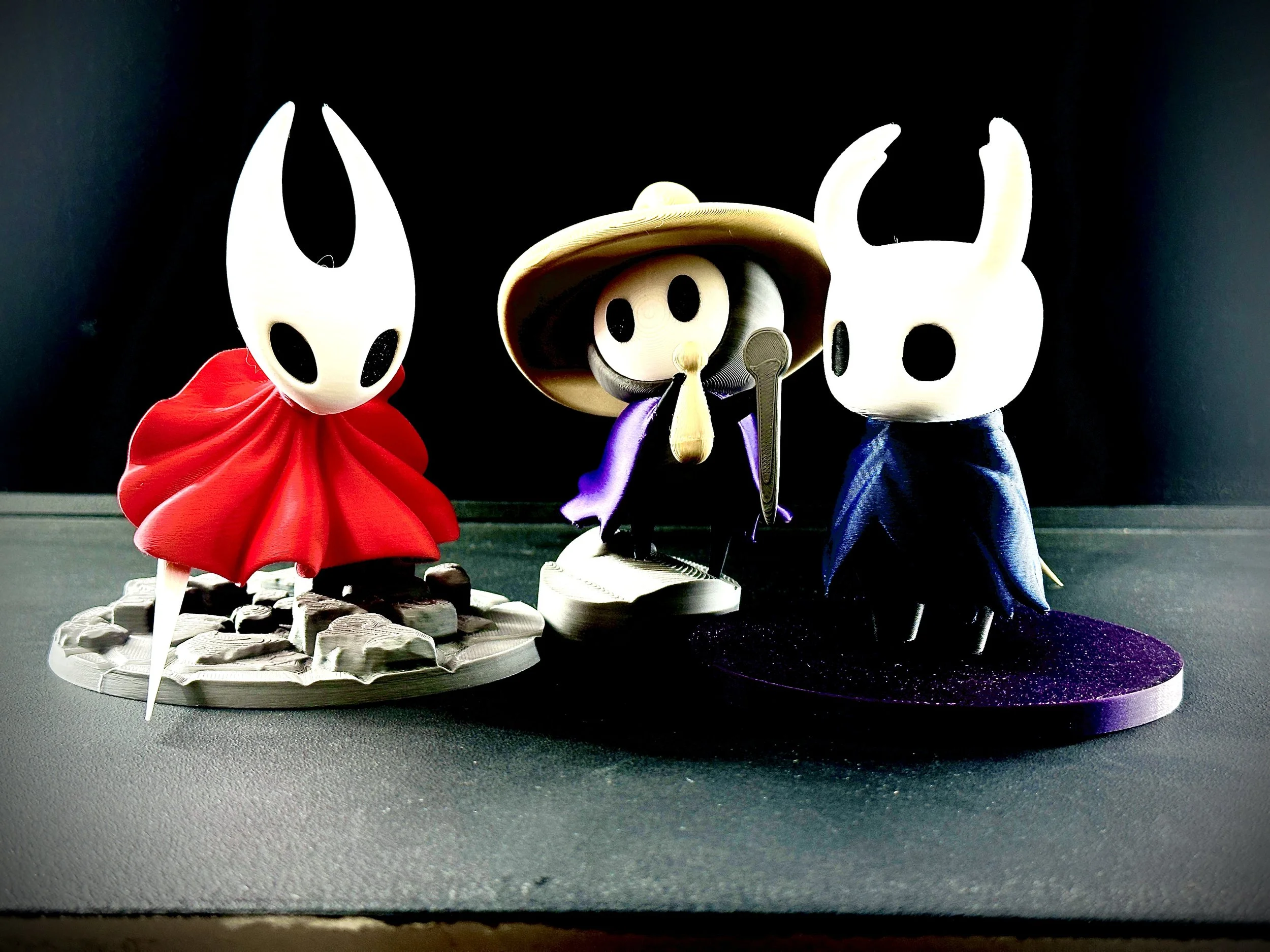Figuras de Hollow Knight impresas en filamento multicolor.