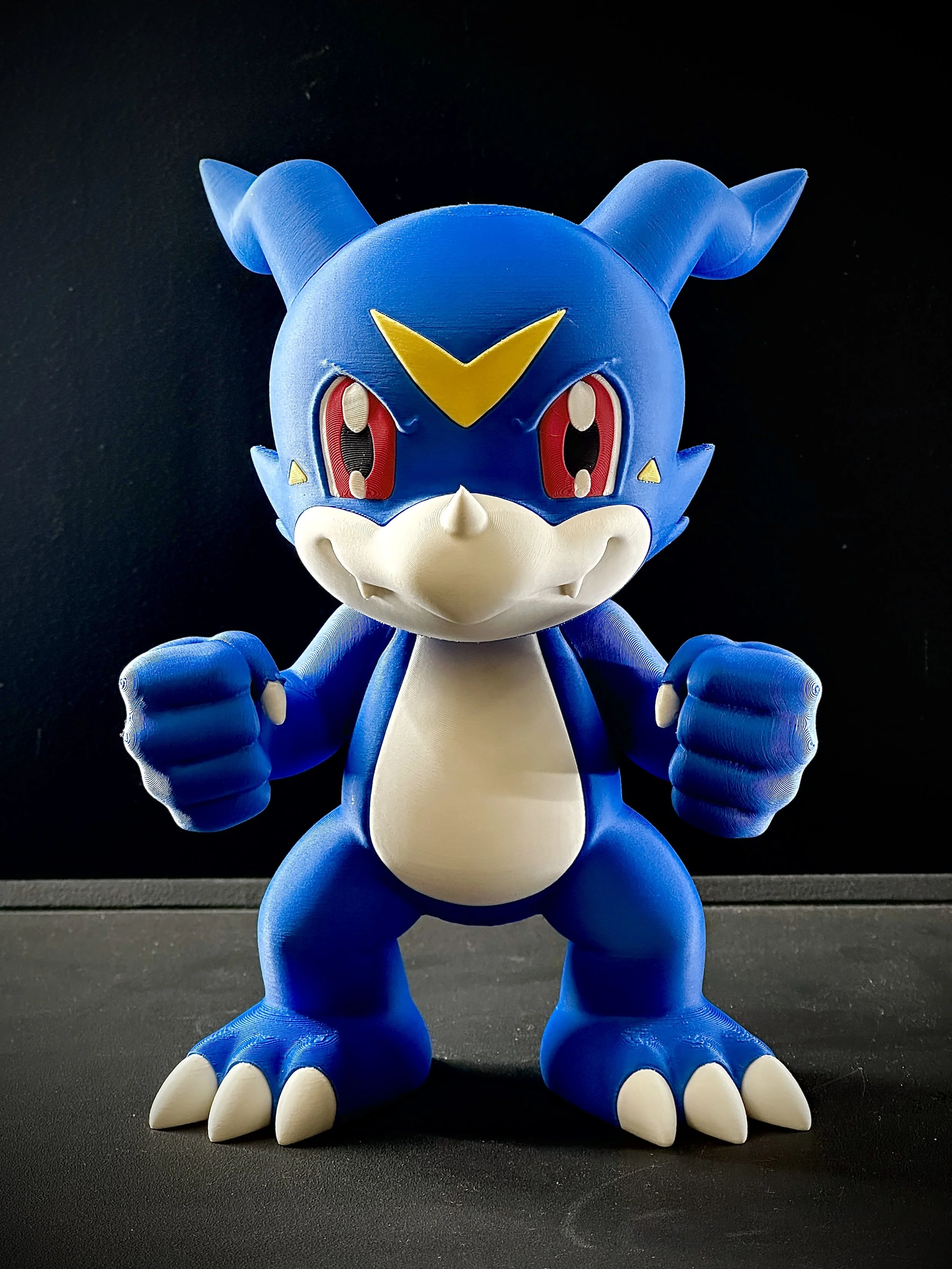 Figura de Veemon impresa en filamento a color.