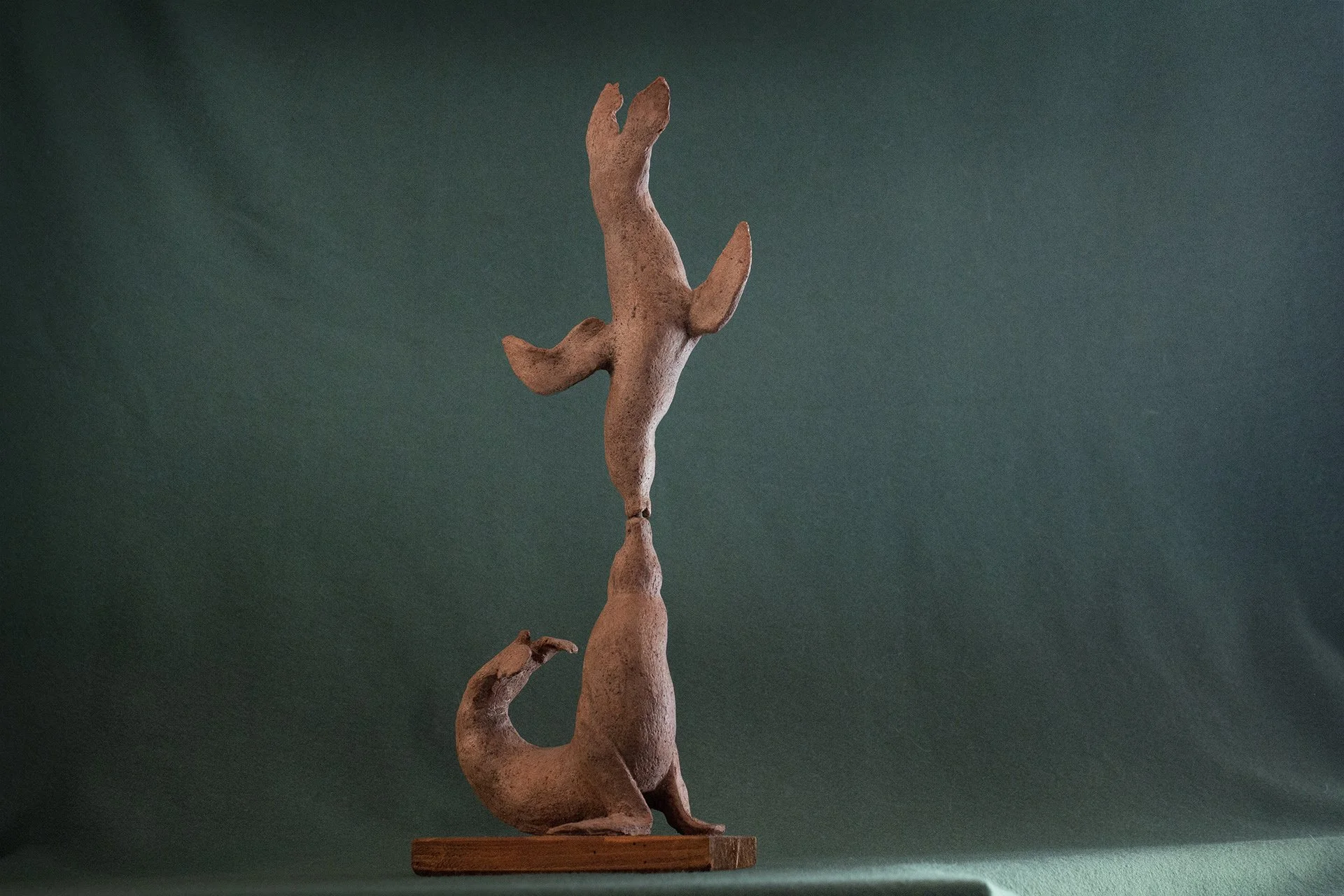 Sculpture en terre. Une otarie en porte une autre en équilibre sur son museau. C’est comme un baiser. Clay sculpture. One sea lion is balancing another on its snout. It’s like a kiss.