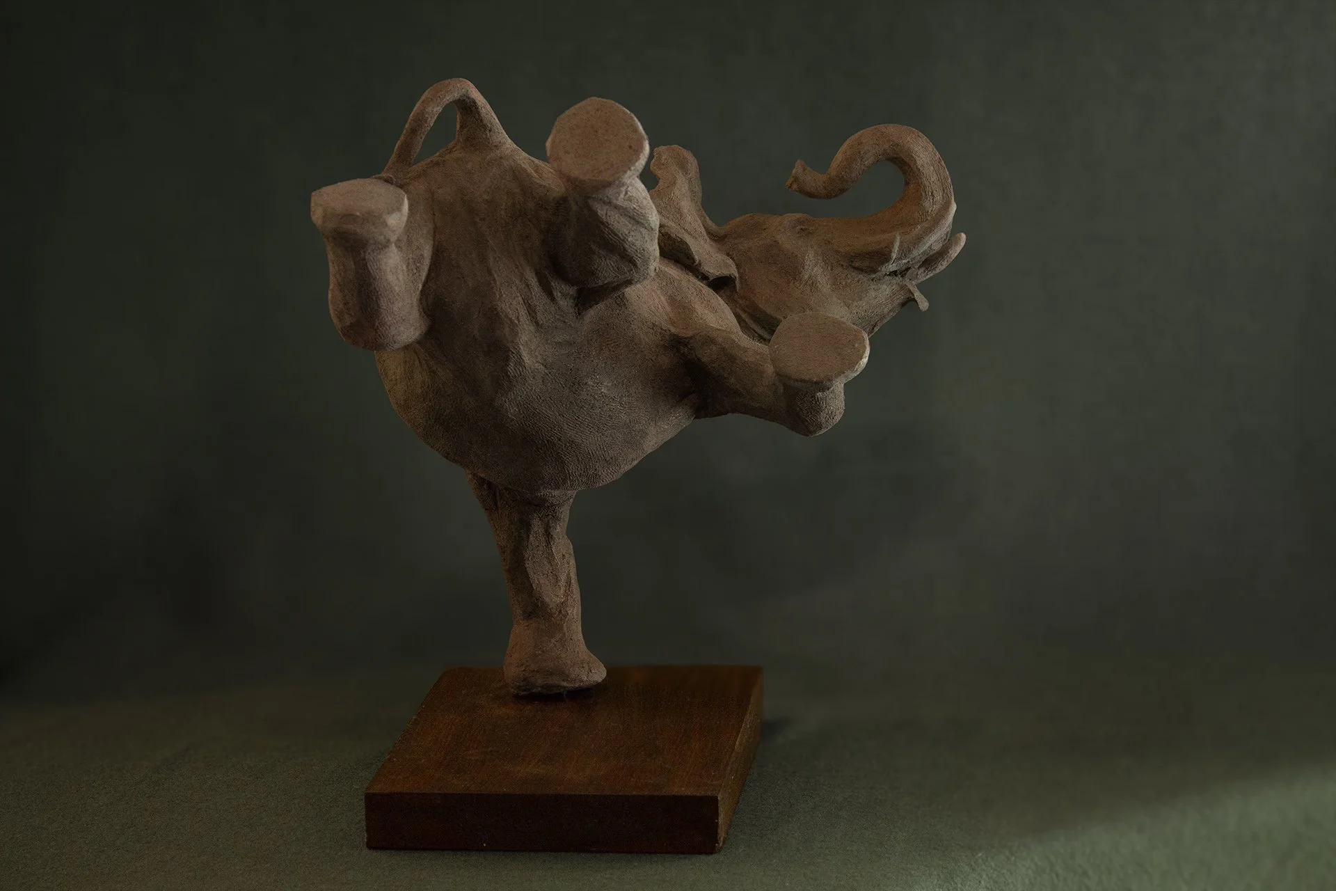Sculpture en terre. Un éléphant en apesanteur nage sous l’eau et touche le fond de la patte. Clay sculpture. A weightless elephant swims underwater, touching the bottom with its foot.