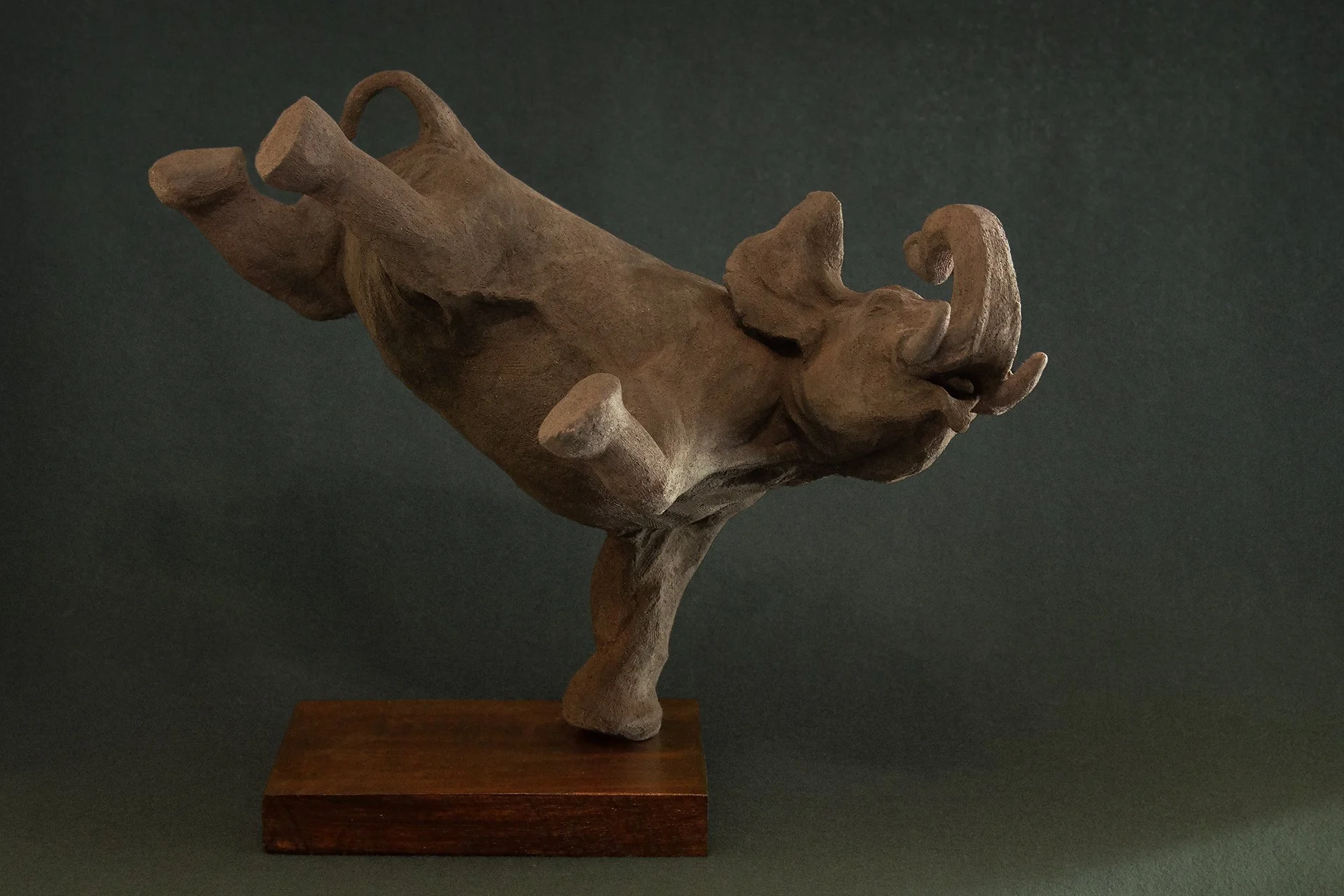 Sculpture en terre. Un éléphant en apesanteur nage sous l’eau et touche le fond de la patte. Clay sculpture. A weightless elephant swims underwater, touching the bottom with its foot.
