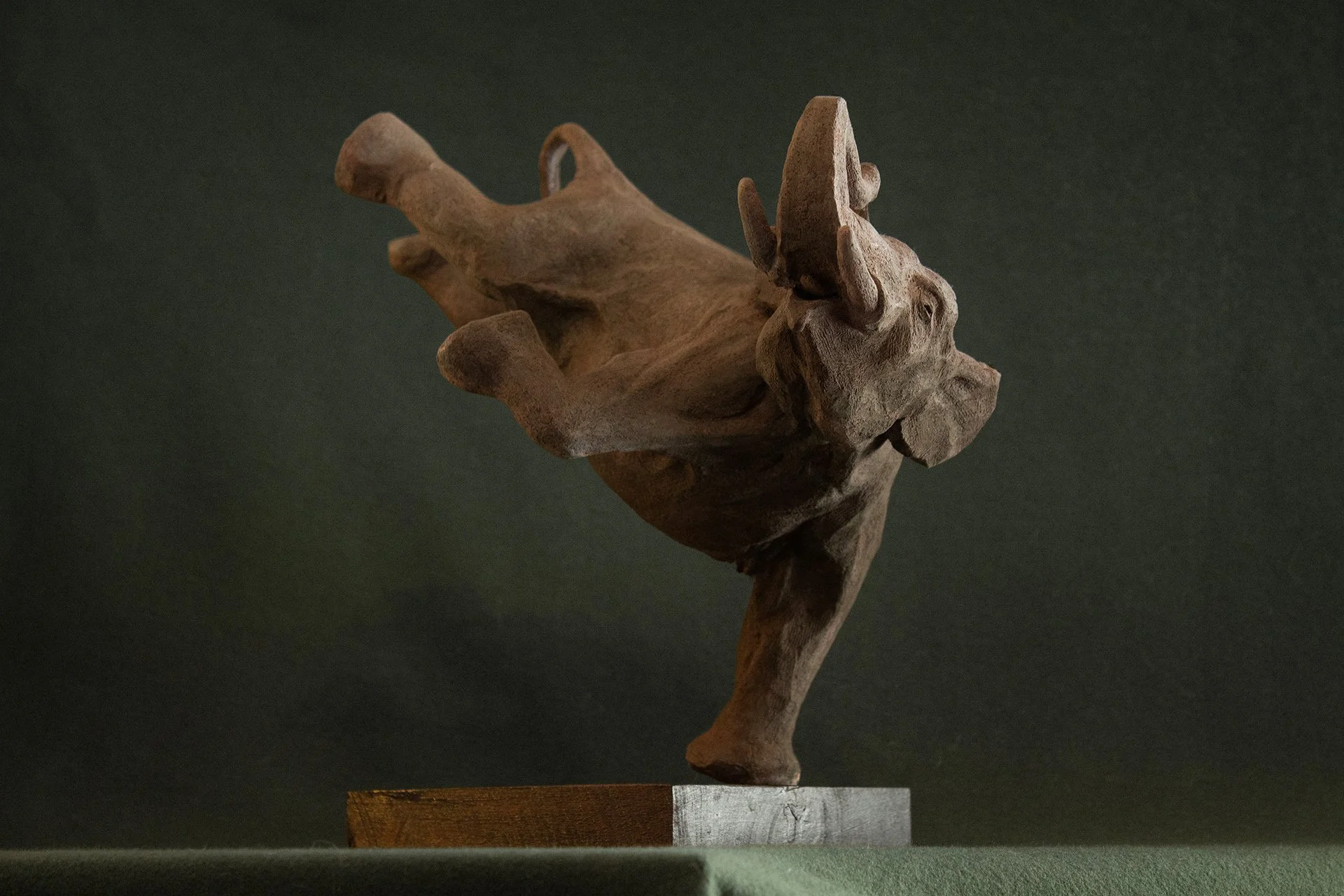 Sculpture en terre. Un éléphant en apesanteur nage sous l’eau et touche le fond de la patte. Clay sculpture. A weightless elephant swims underwater, touching the bottom with its foot.