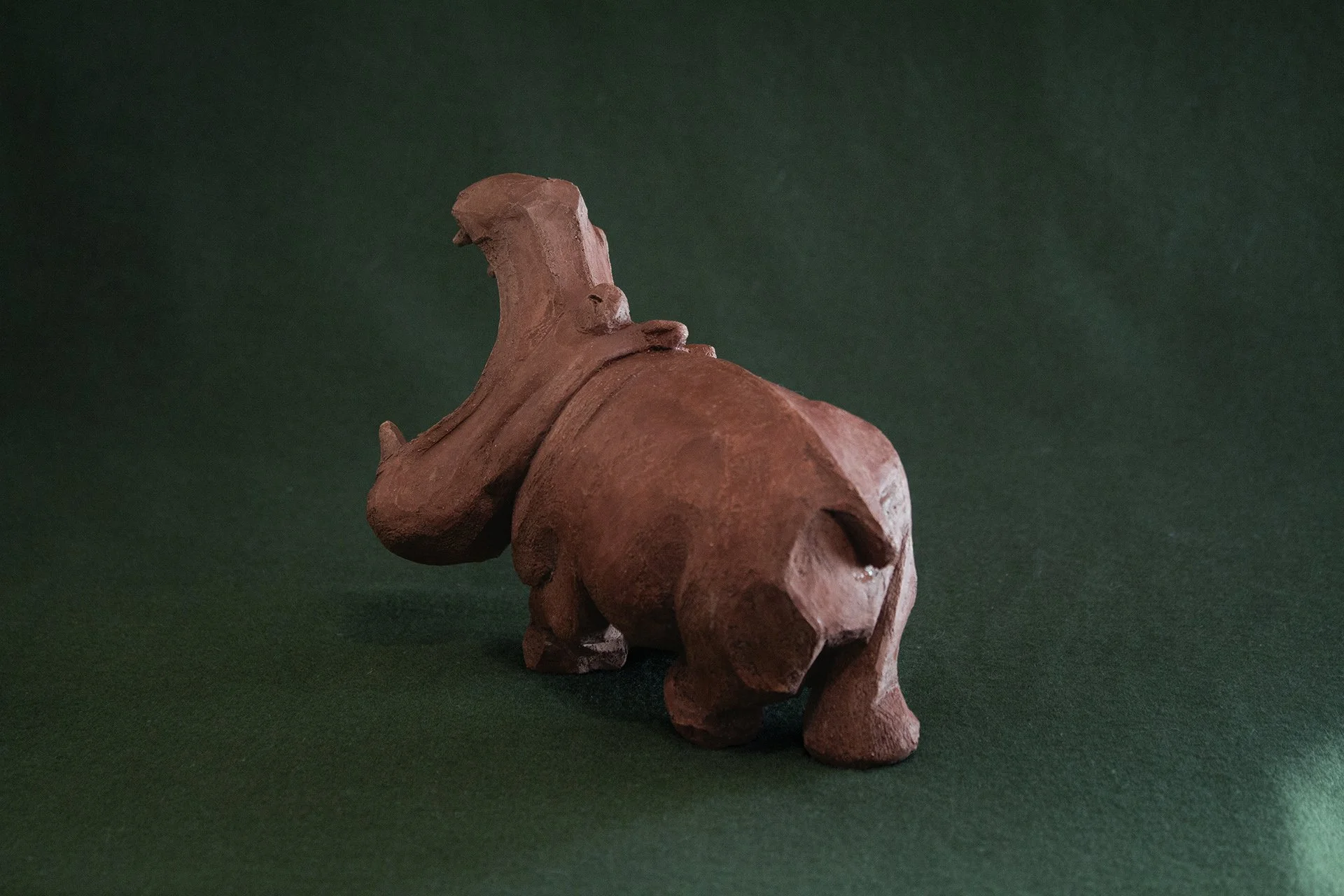 Sculpture terre. Un hippopotame chante la gueule grande ouverte. Clay sculpture. A hippopotamus sings with its mouth wide open.