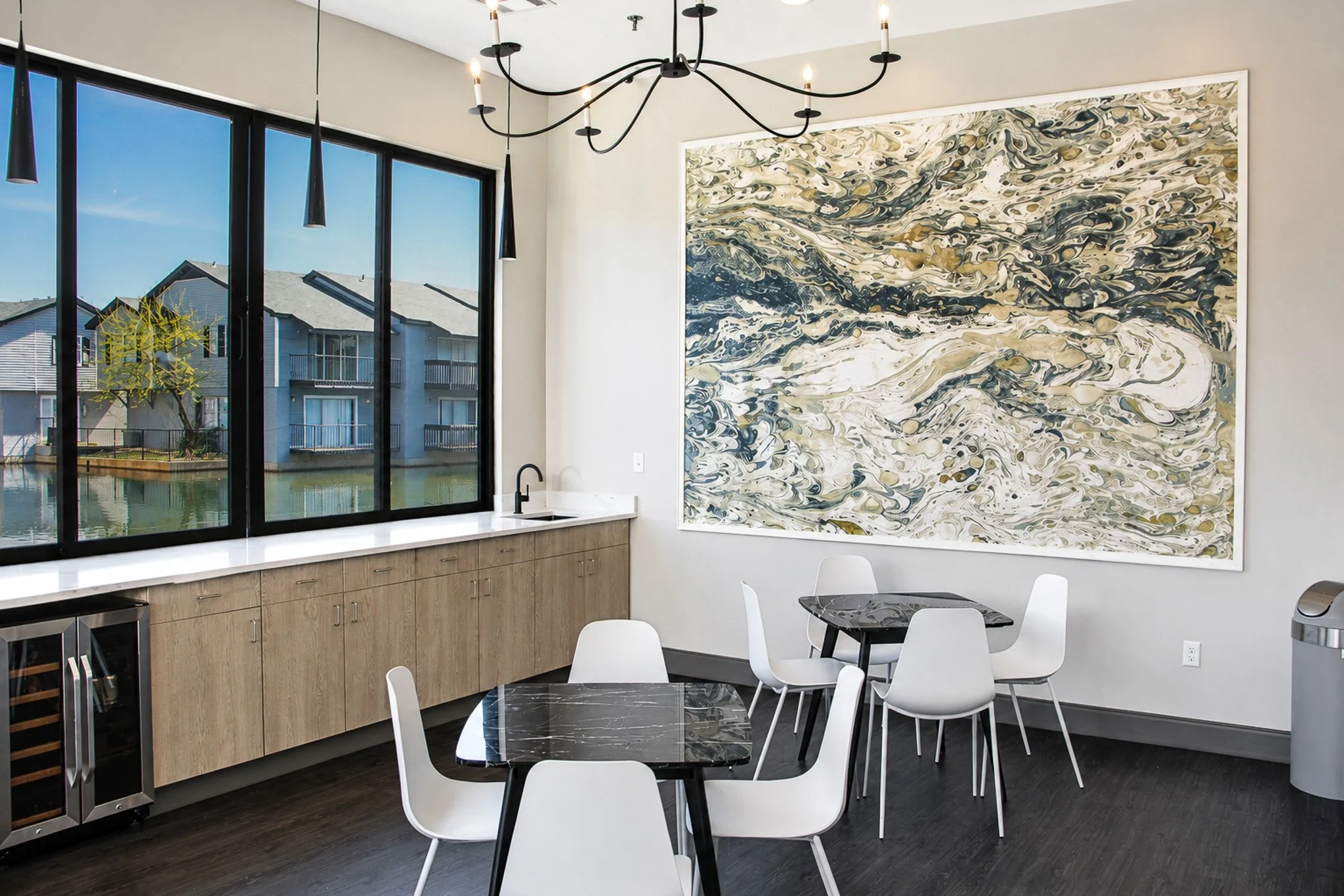 Party room with ample counter space, mini fridge, sink and tables and chairs.
