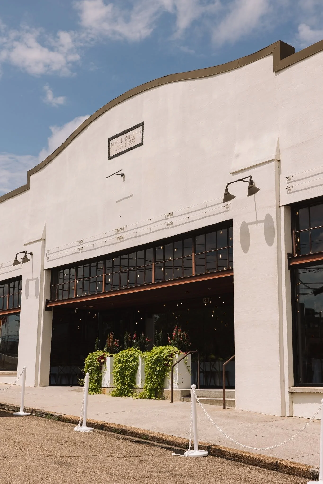 Exterior of The Press Room, a historic Knoxville wedding and event venue featuring a white façade, large windows, and an inviting entrance.