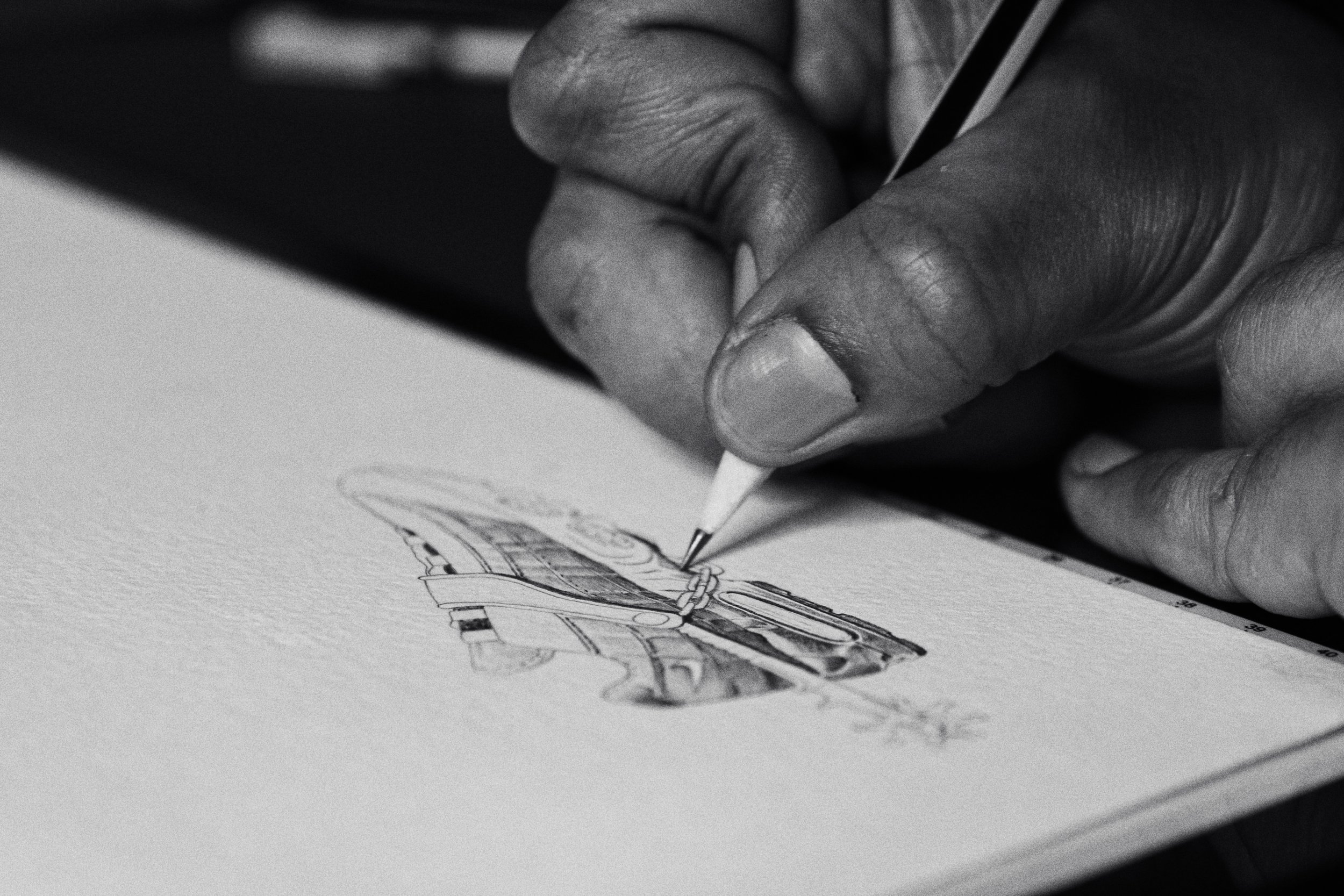 Close-up of a hand drawing with a pencil on paper, artistic sketch in progress.