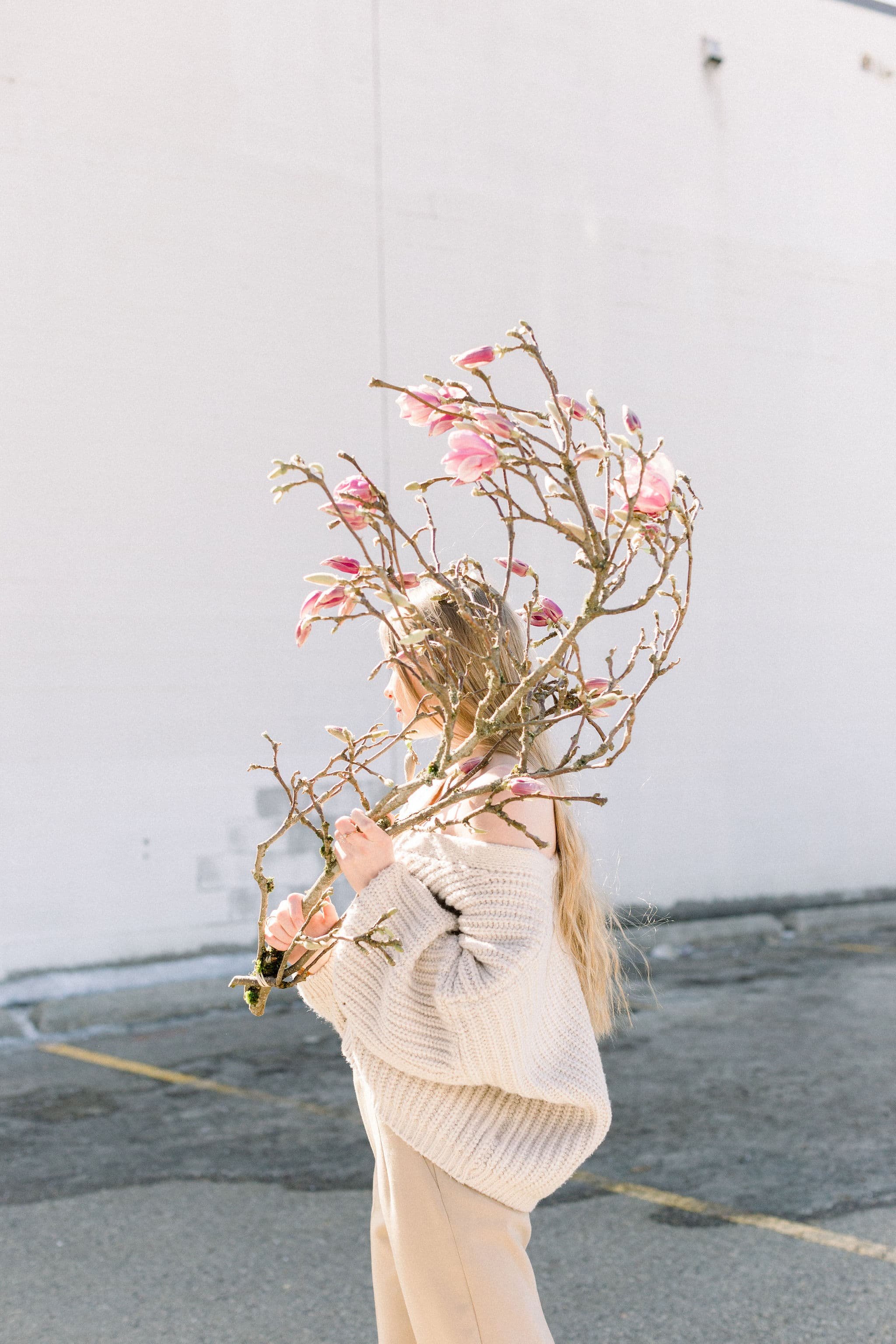 A Twig & Bloom model holding a blooming magnolia branch in Regina SK.