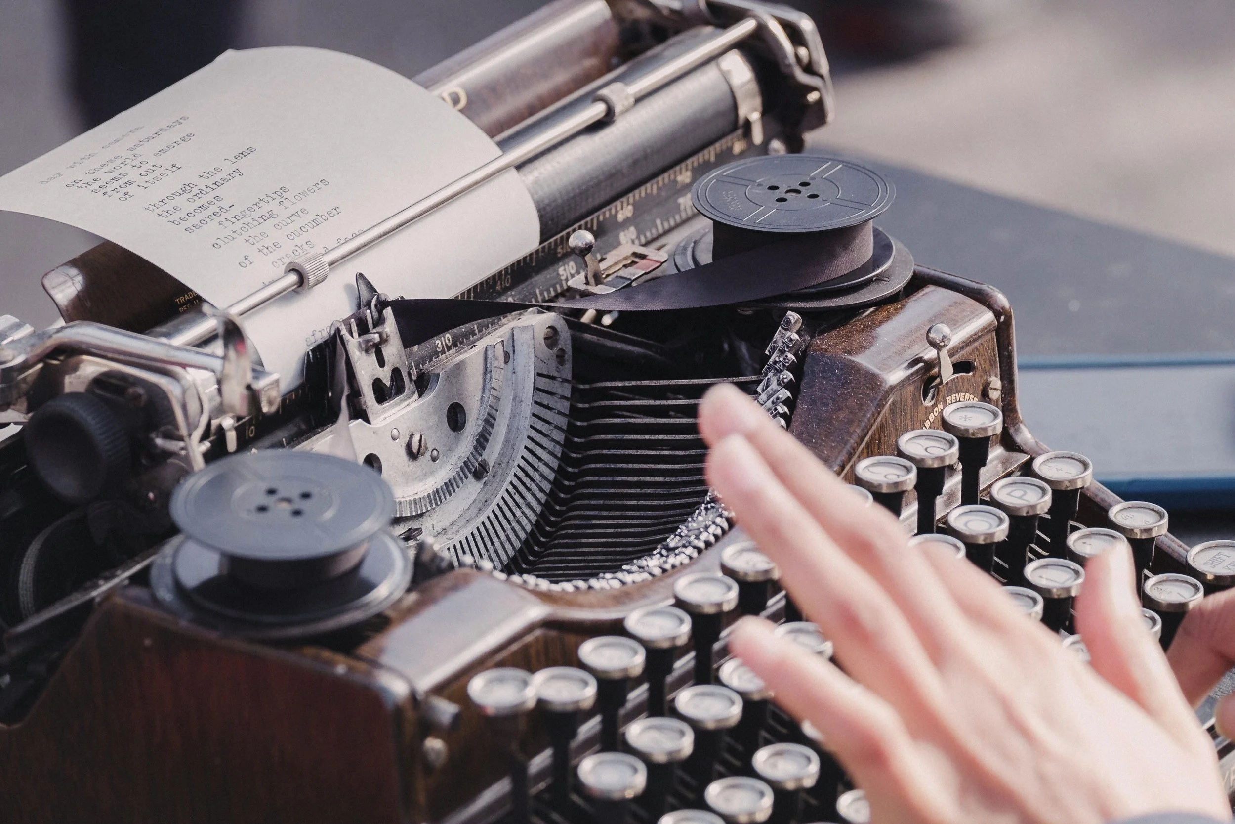 Close-up of a photo of a hand typing on a early 1900s typewriter