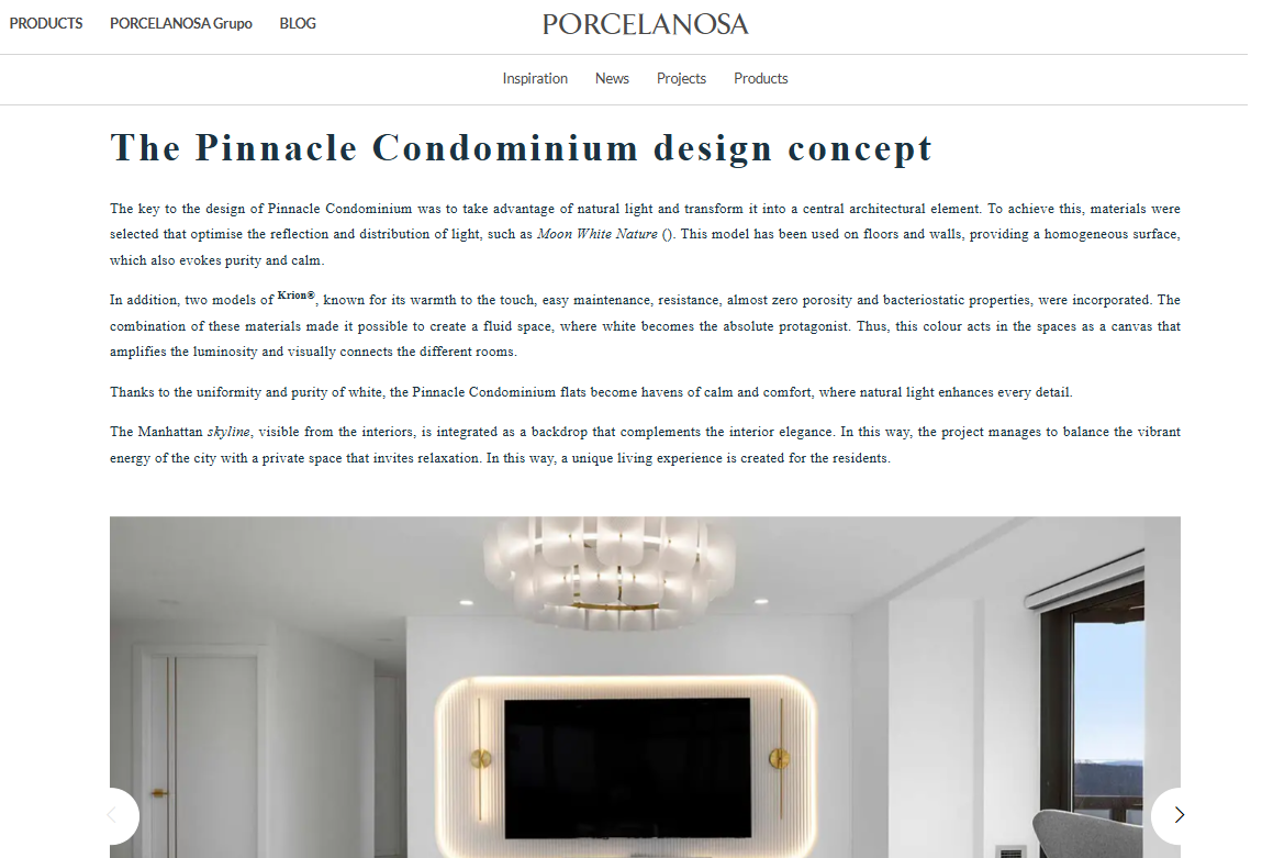 Modern white condominium interior with a large black television mounted on a wall, featuring a rounded, illuminated frame. A stylish chandelier hangs from the ceiling, and a window shows an outside view.