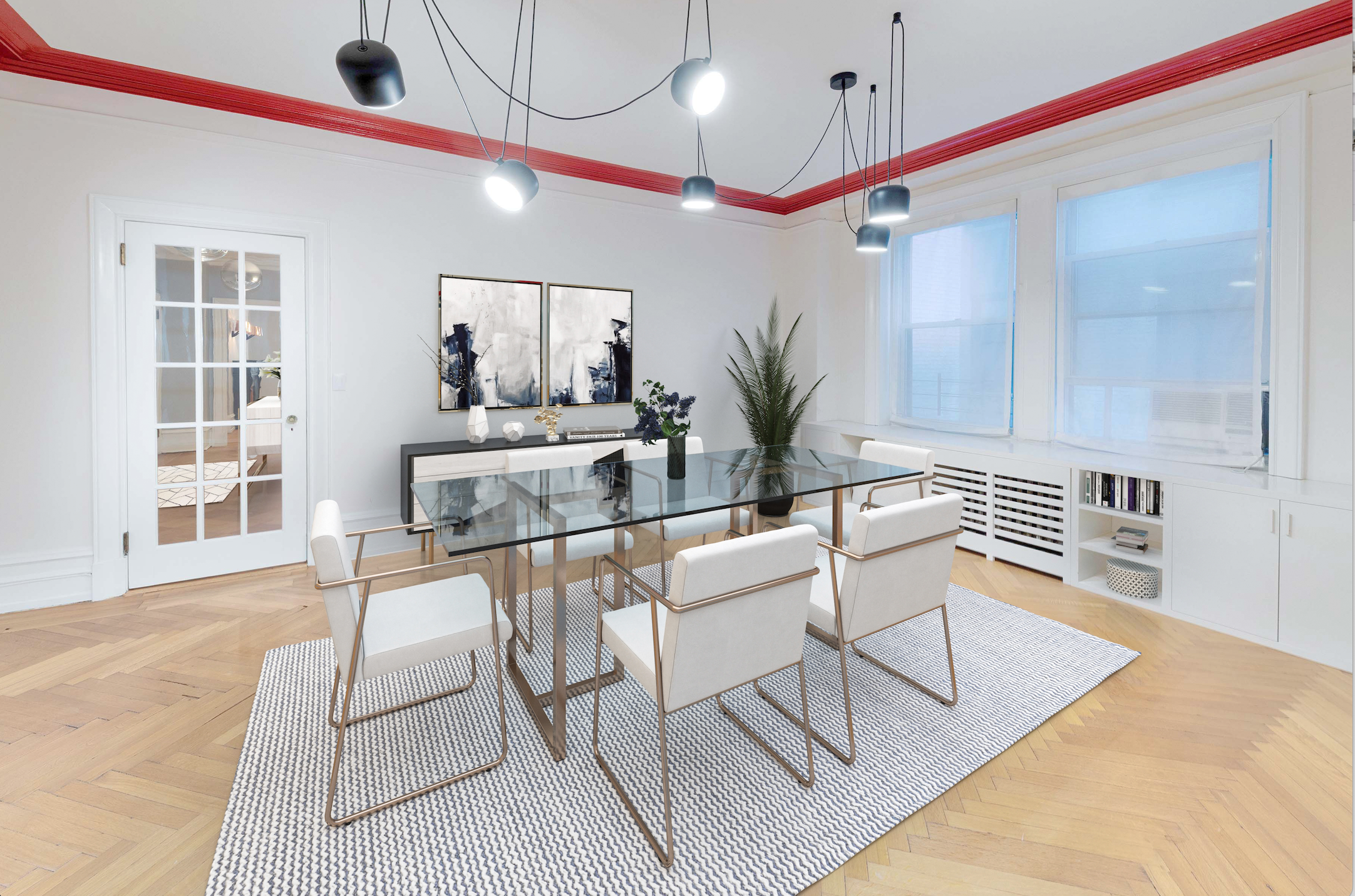 Modern dining room with six white chairs around a glass table, black pendant lights hanging from the ceiling, a hat pattern black and white rug on hardwood floor, white walls with red crown molding, large windows with white blinds, a black sideboard with abstract artwork and decorative items, and a tall potted plant.