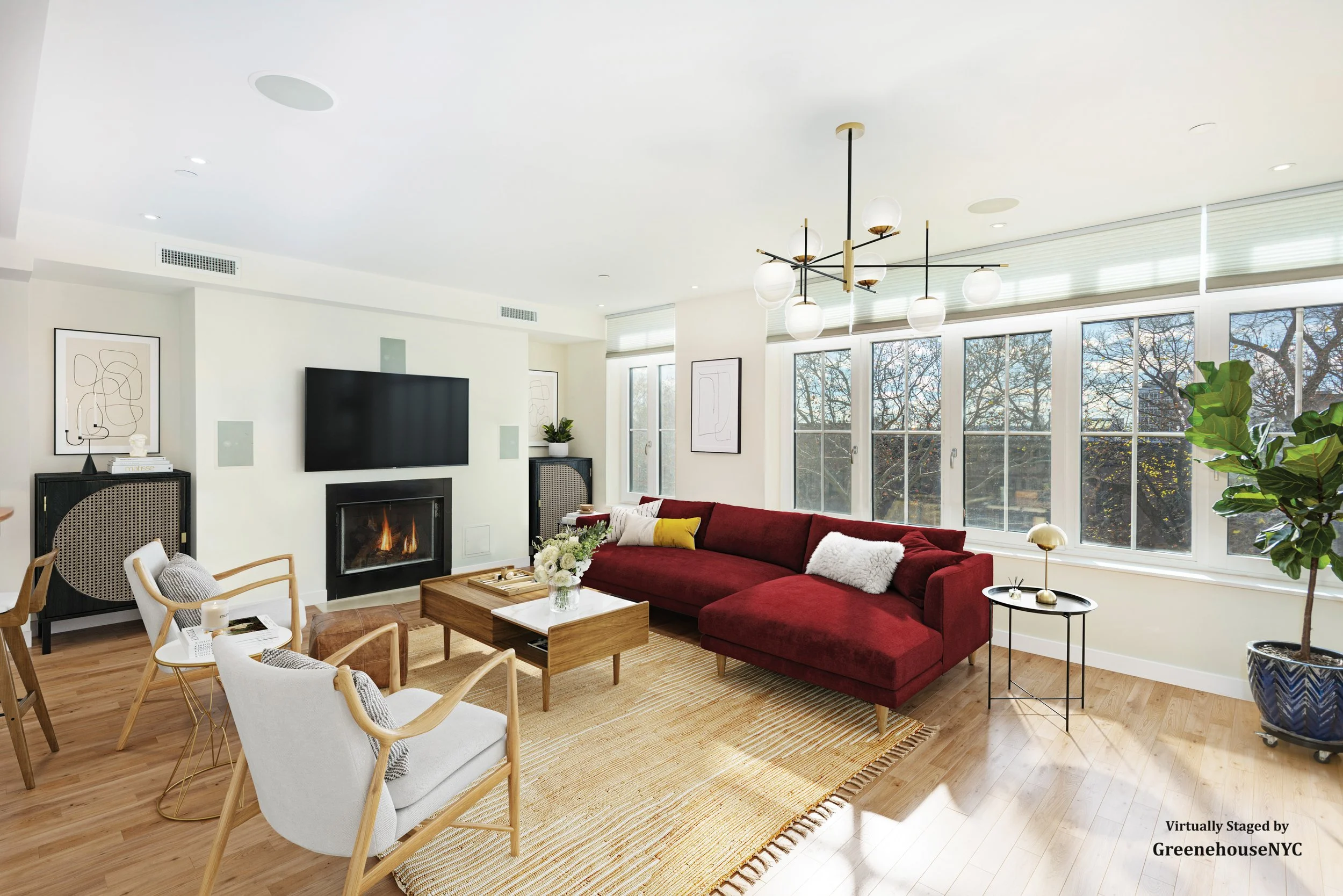 Bright living room with large windows, red sectional sofa, modern chandelier, fireplace, and minimal decor.