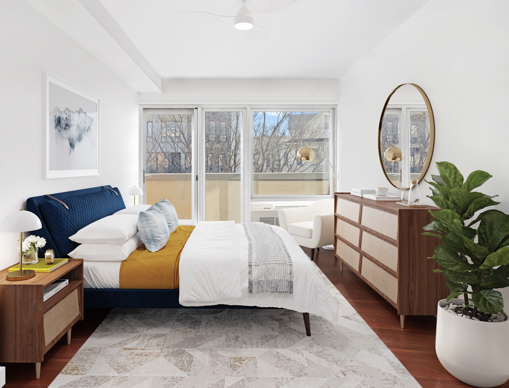 Bright and modern bedroom with large window, white walls, blue headboard, white bedding, wooden furniture, a green potted plant, and a round mirror.