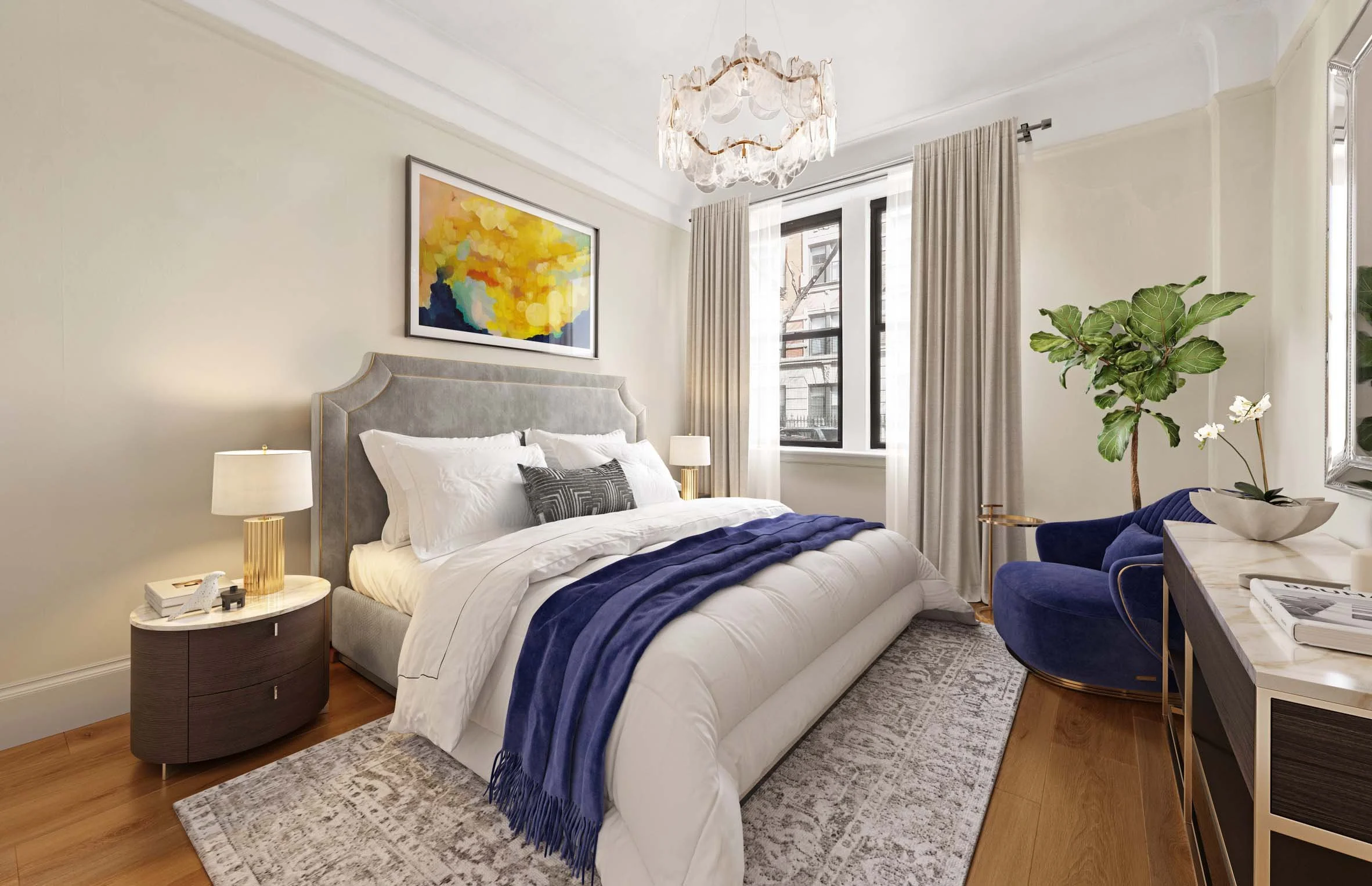 Modern bedroom with a large bed, white and gray bedding, a blue throw blanket, and decorative pillows. There is a bedside table with a lamp and decor. A window with cream curtains lets in natural light. A blue velvet chair with a plant, a marble-topped dresser with plants, and a colorful abstract painting on the wall.