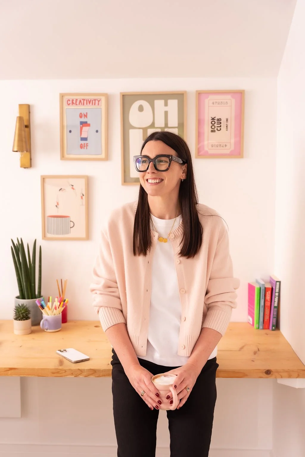 Harriet Cox in a pink cardigan in her office
