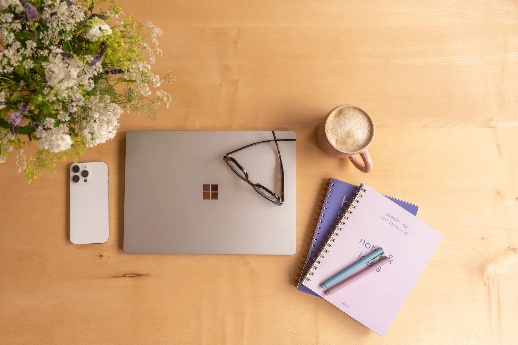 a collection of things on the desk including a PC and a notebook