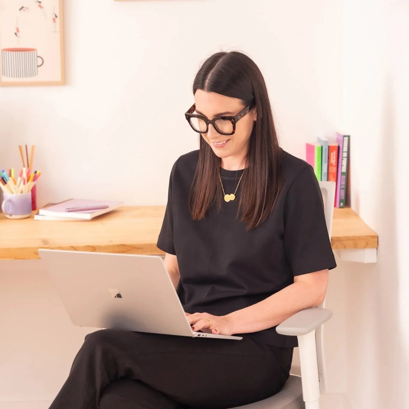 Harriet working at her laptop inside her office