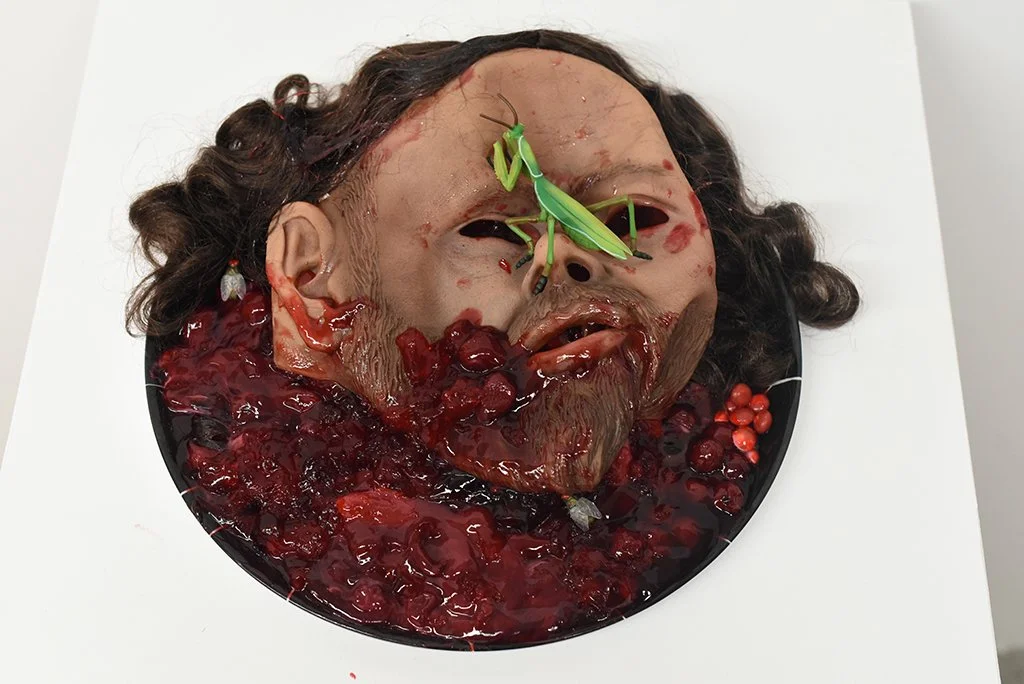 Sweet Solome, 12”  diameter, ~3” high, Latex masc, plastic, resin, synthetic hair, cherry and strawberry pie filling, red Skittles, red M&Ms, Swedish Fish, strawberry syrup, plastic platter. 2023. 
