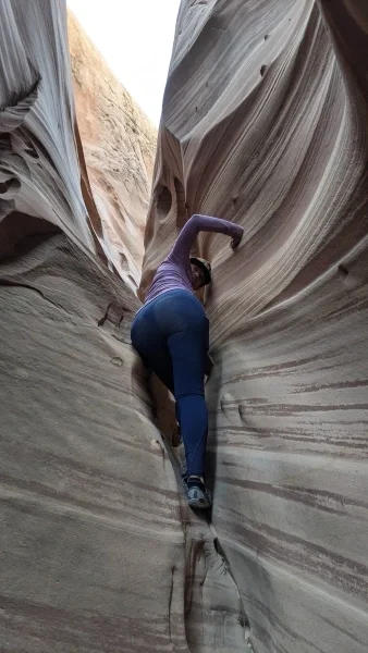 Person climbing through a slot canyon