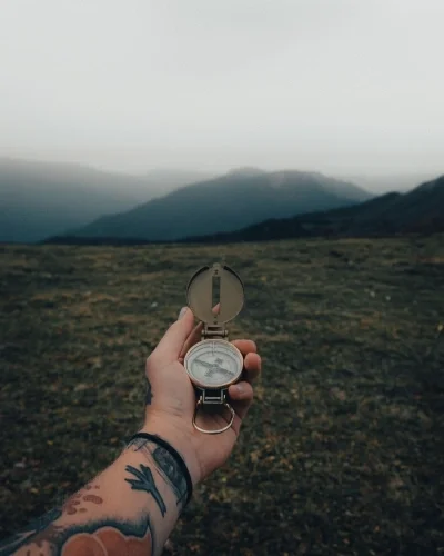 Person holding a compass in a mountain environment