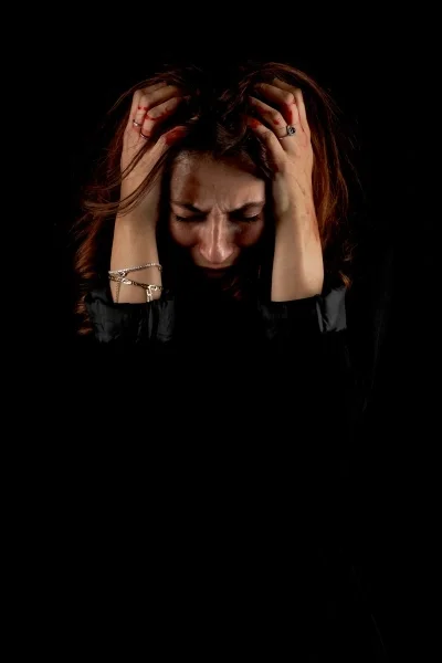 Woman with hands on head looking distressed