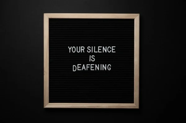 Square letterboard with the phrase "Your silence is deafening"