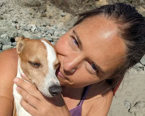 Woman holding a small dog close to her face