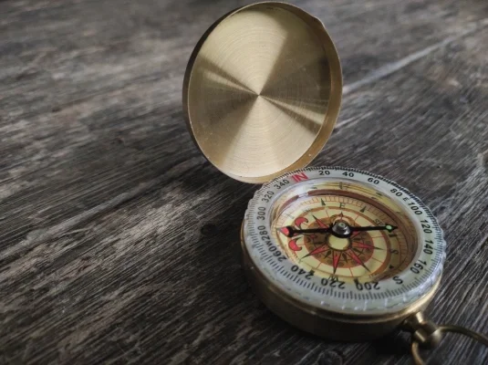 Close up of a compass on a wooden table