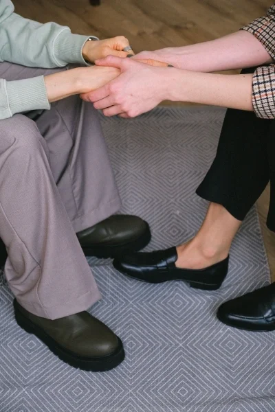 Close up of two people holding both hands