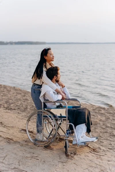 Couple at the beach with the man in a wheelchair