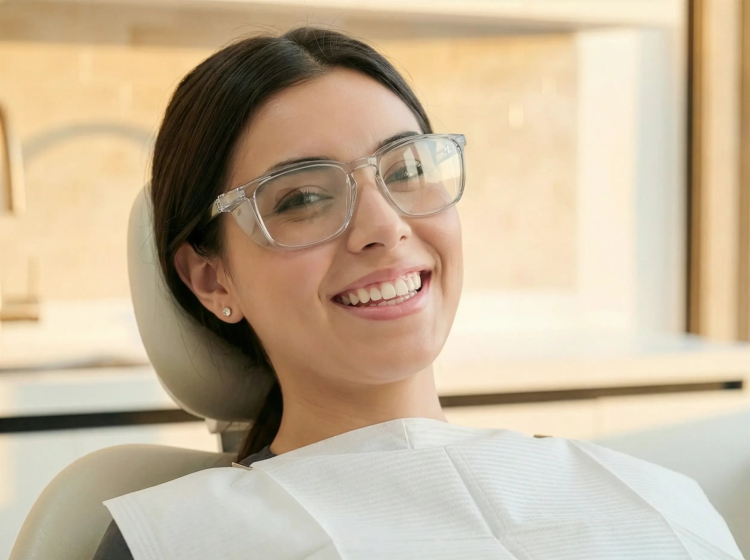 Paciente mujer sonría cámara con gafas protectoras en Clínica Aires.