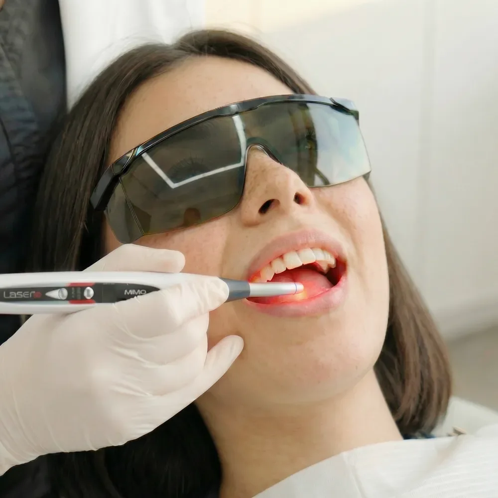 Paciente recibiendo tratamiento láser para aftas y otras lesiones bucales.